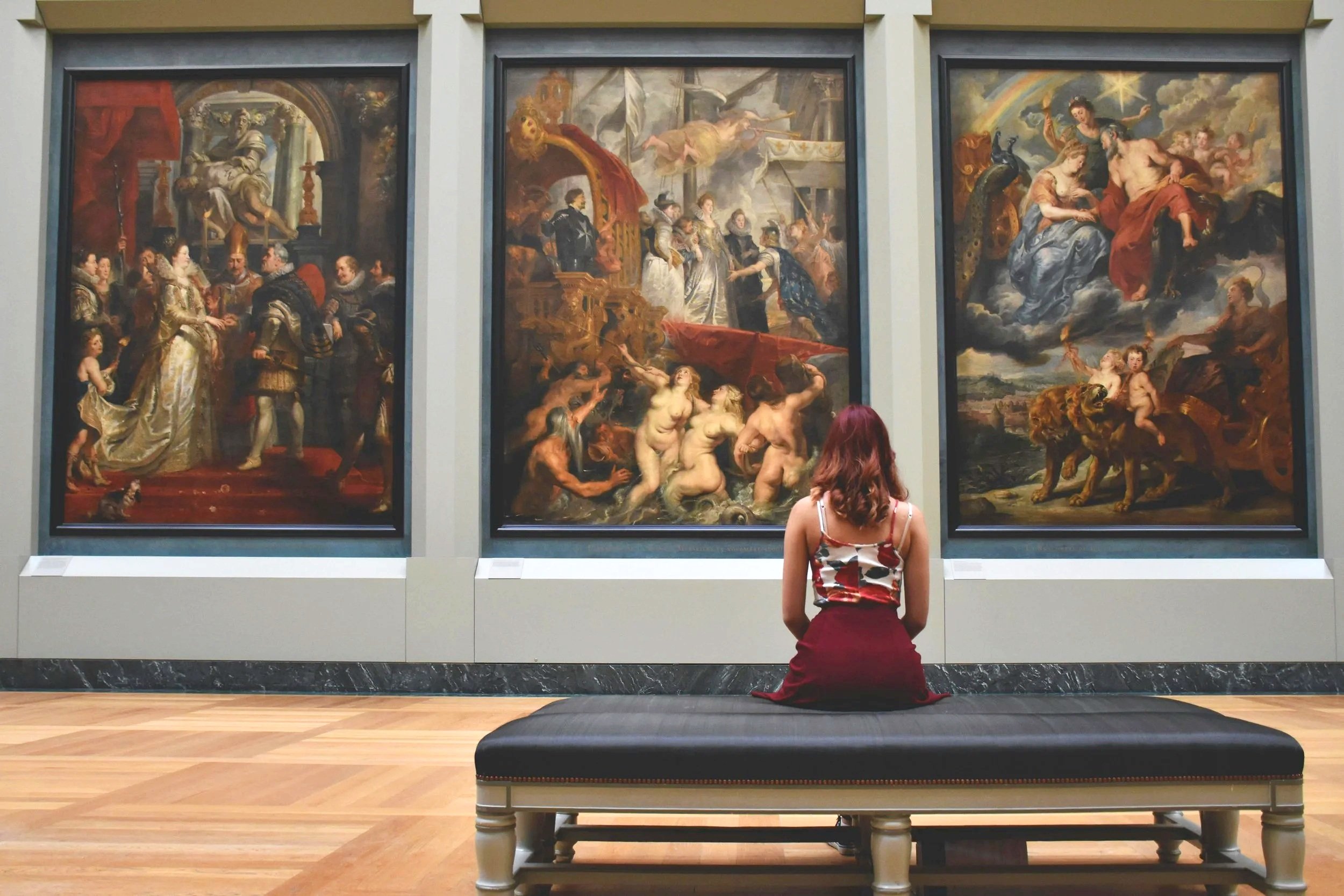 A person sitting contemplatively in an art museum.