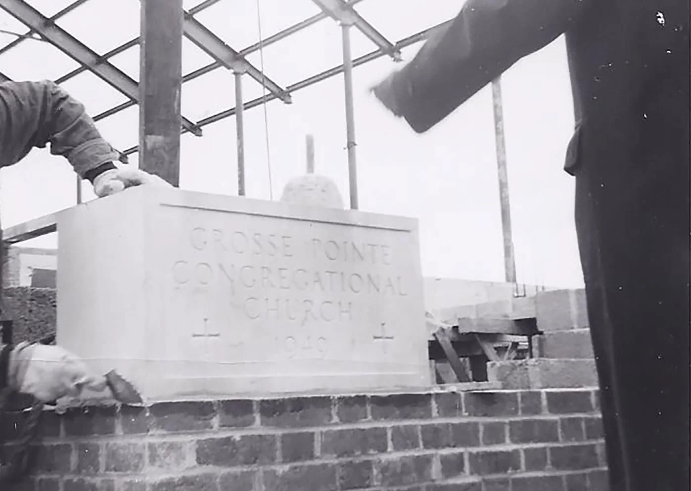 Construction workers installing a stone marker in front of a new church building at Grosse Pointe Congregational Church in 1942.