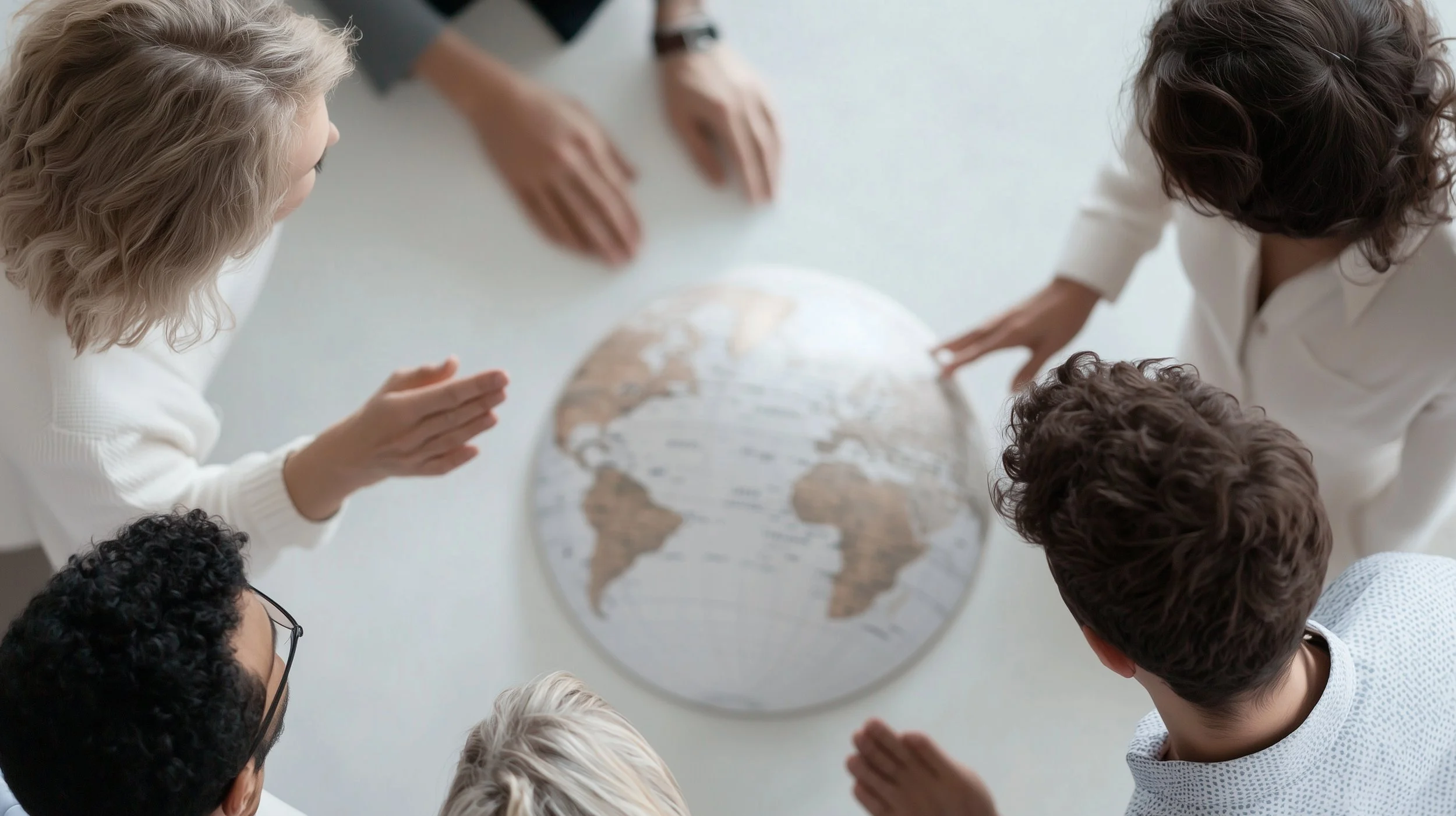 Group gathered around a globe representing international collaboration and global communication.