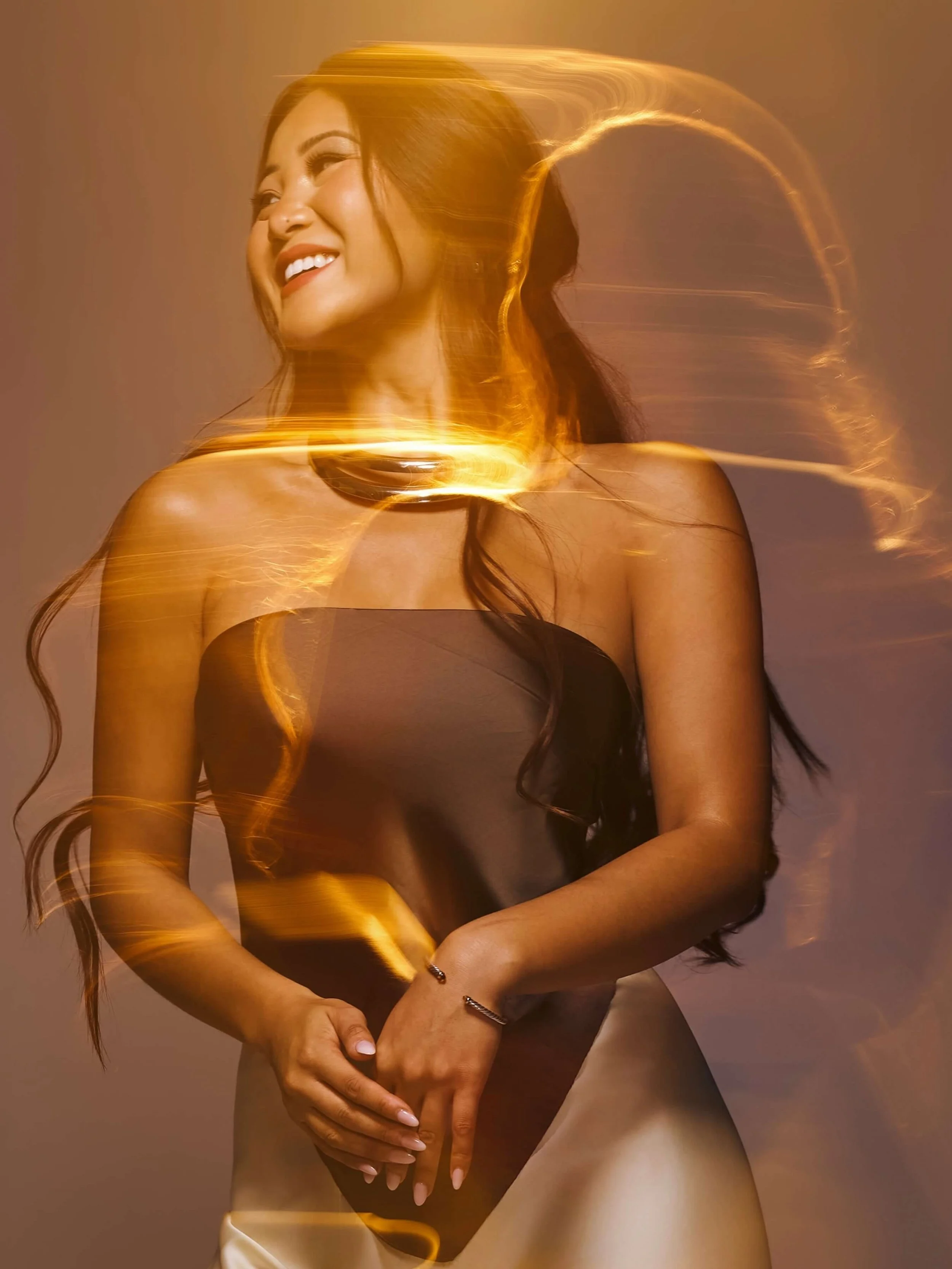 Creative portrait of a woman with light streak effects, photographed in a studio setting for a commercial photography campaign