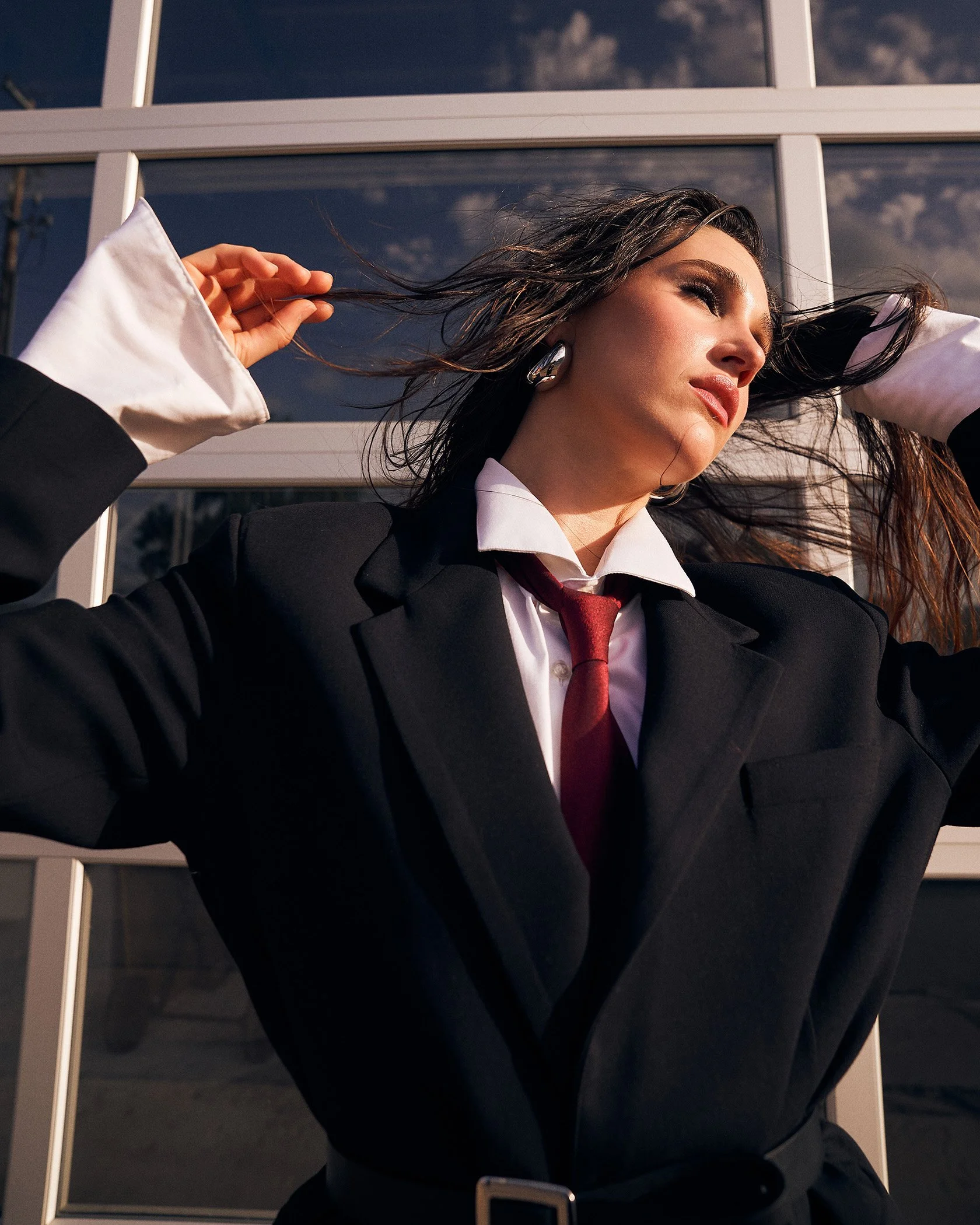 Professional portrait of a woman in a business suit outdoors near modern architecture, captured for corporate branding photography