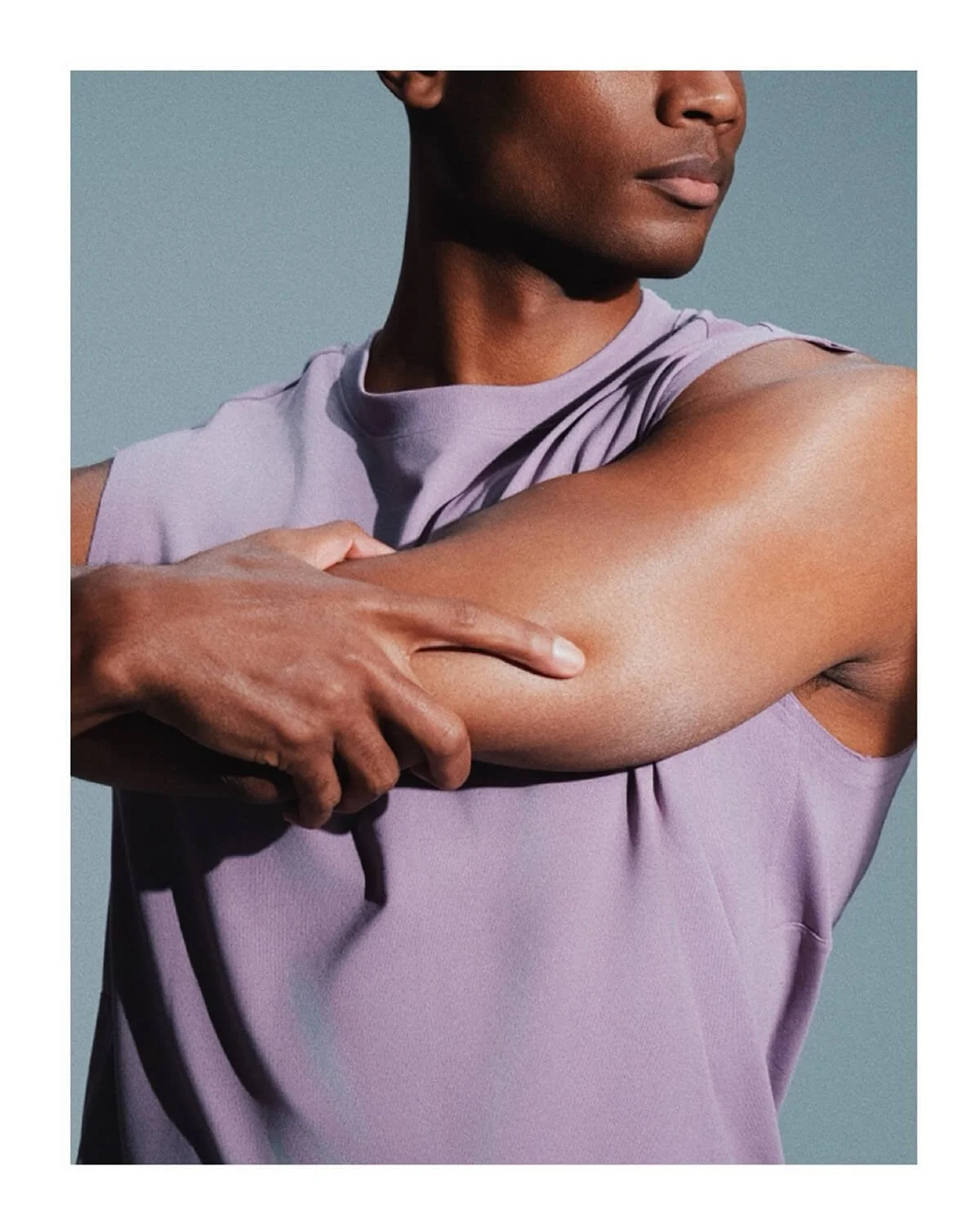 Close-up fitness photograph of an athlete stretching their arm, captured for a commercial activewear campaign
