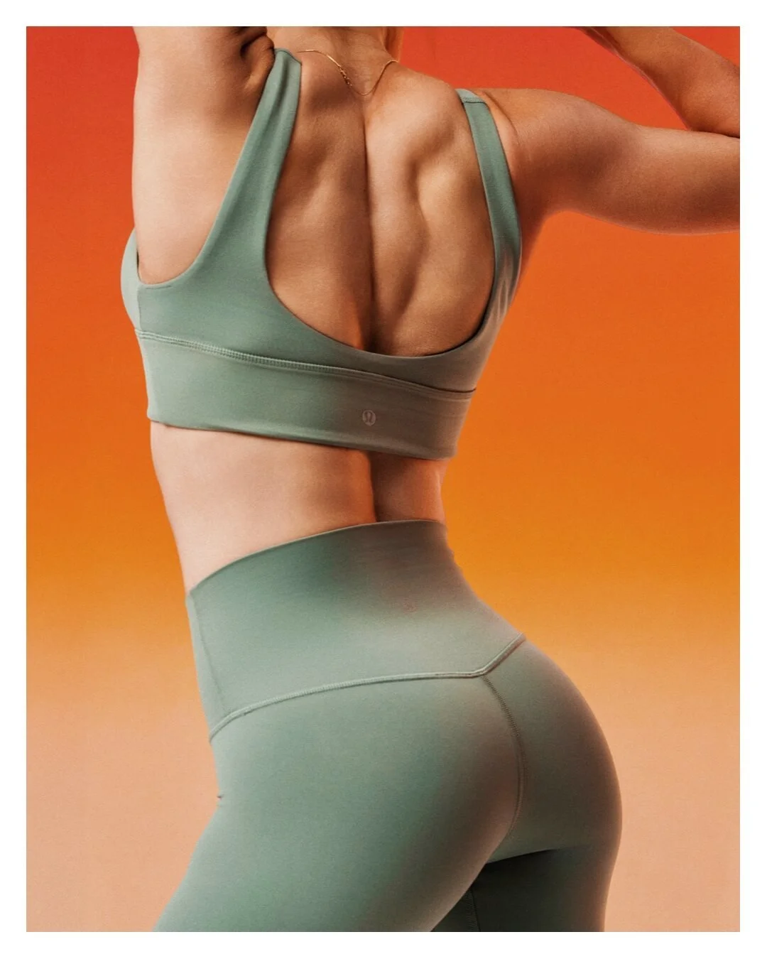 Close-up fitness photograph of a woman in green activewear stretching against an orange background, created for a commercial activewear campaign