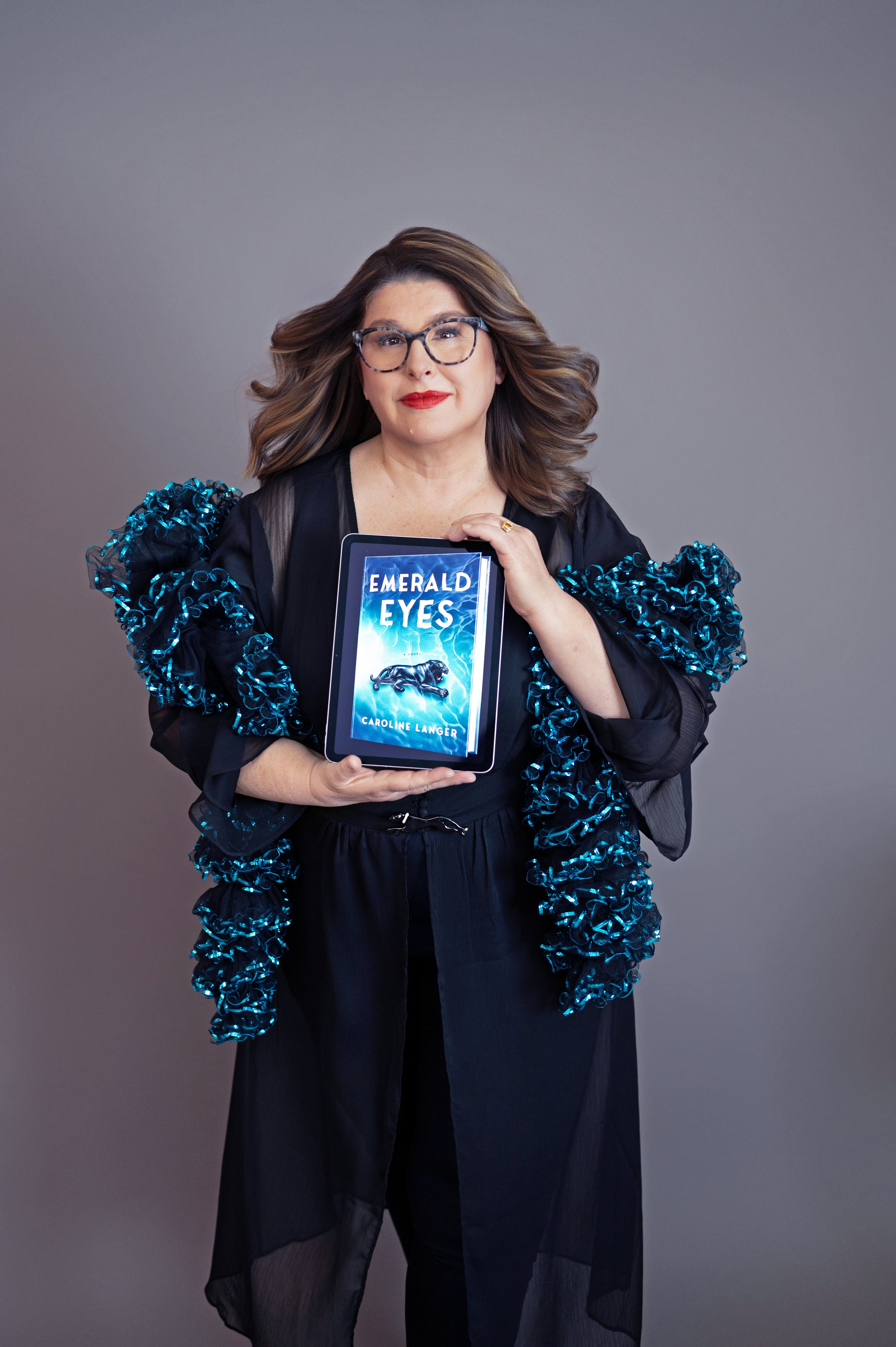 Caroline Langer author or Emerald Eyes a Novel proudly holds her ebook