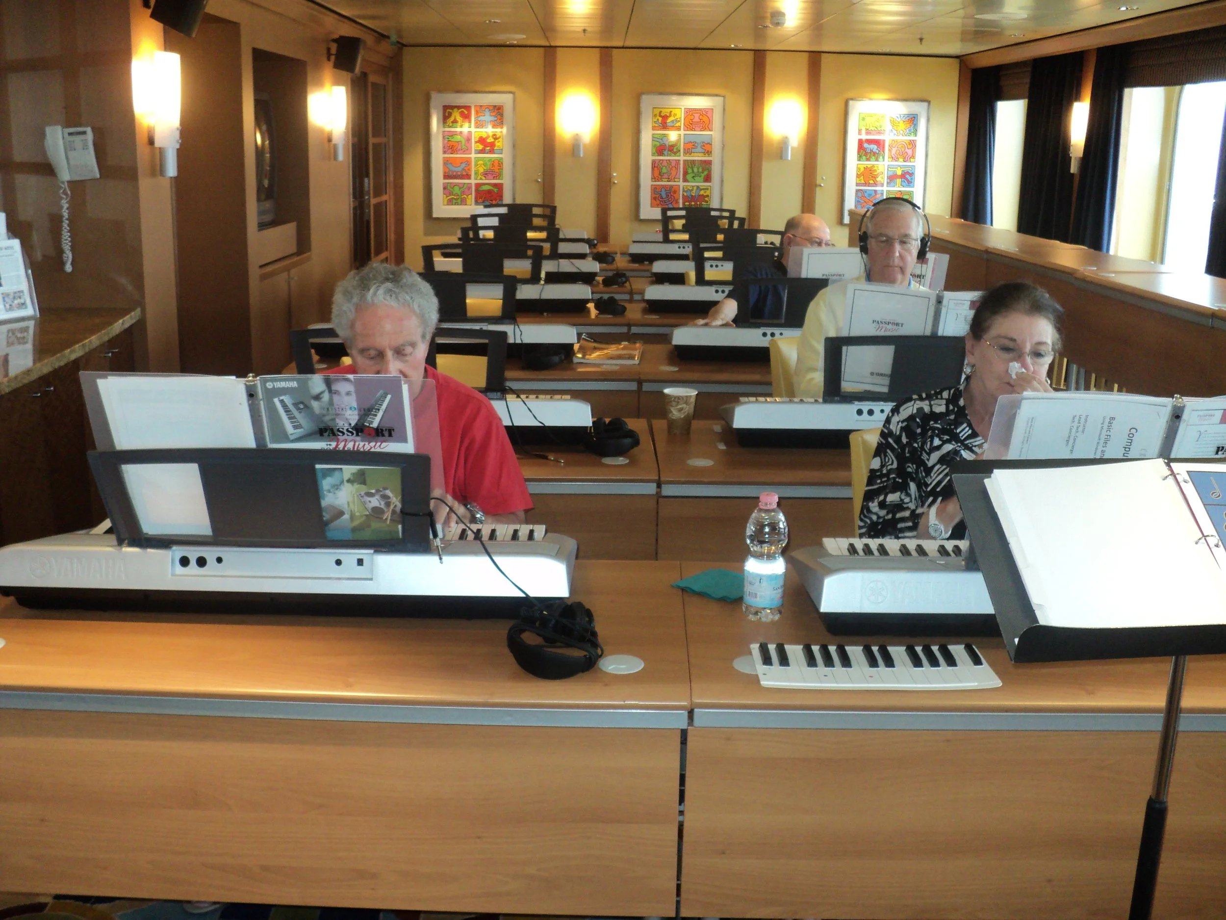 People playing electronic keyboards in a music class or rehearsal room.
