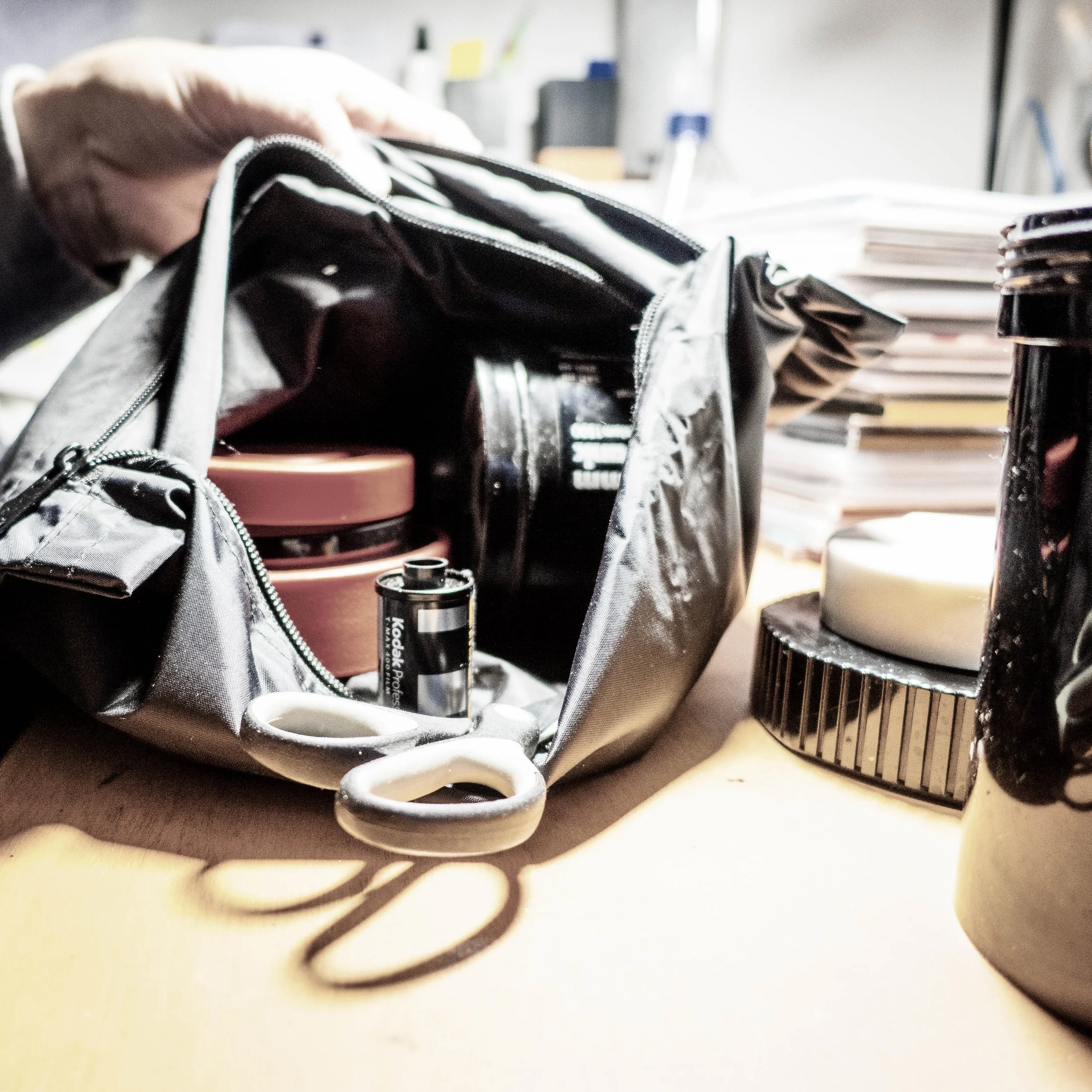 Nahaufnahme eines Rucksacks, eine Wasserflasche und Schreibwaren auf einem Tisch in einem Büro