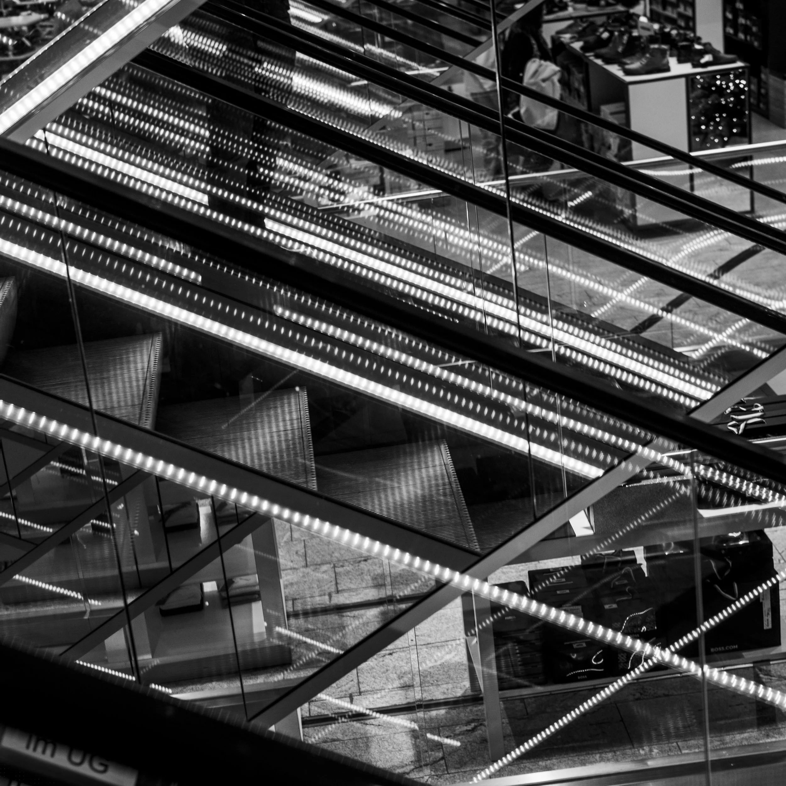 Schwarz-Weiß-Foto eines modernen Gebäudes mit einer vielstöckigen Treppe aus Glas und Metall. 