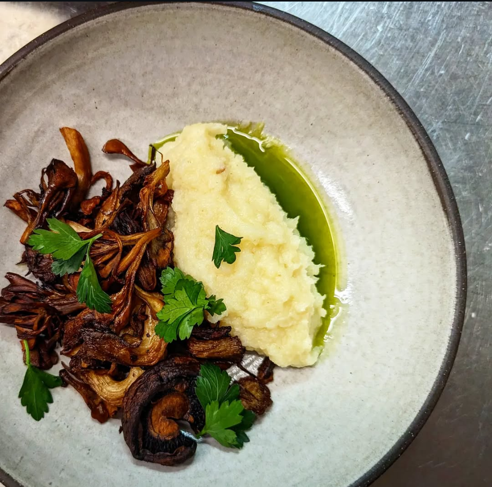 Roasted wild mushrooms served with a side of citrusy parsnip puree, garnished with fresh parsley and drizzled with chive infused olive oil