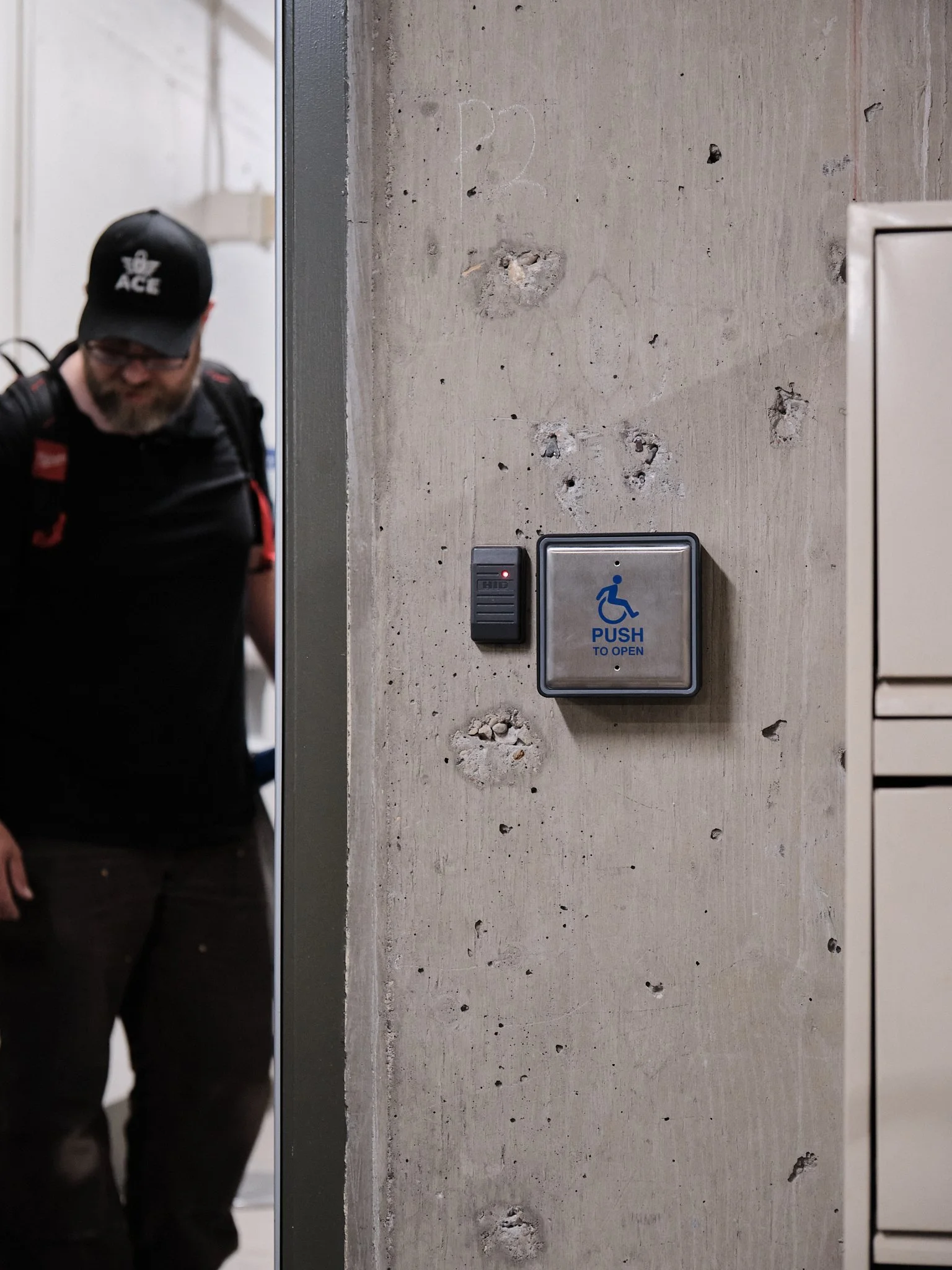 An access control fob reader on a concrete wall in the parkade to a condo building.