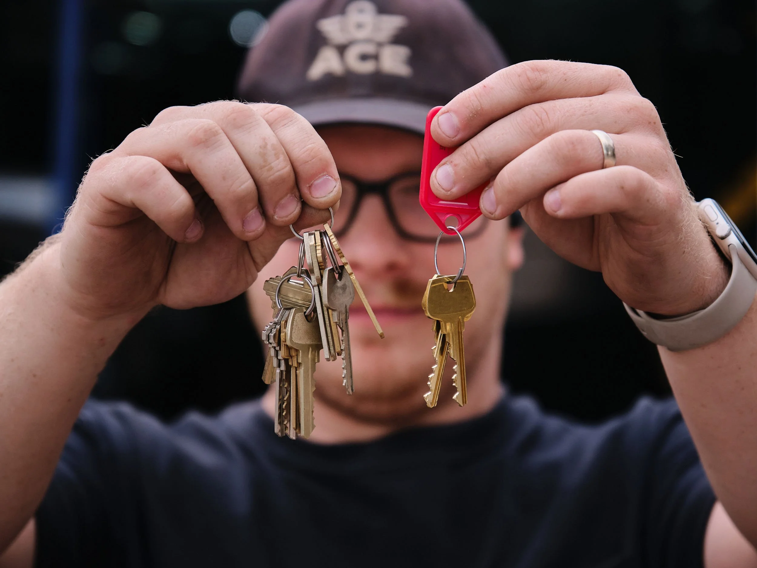 Person holding a set of keys attached to a red key tag.
