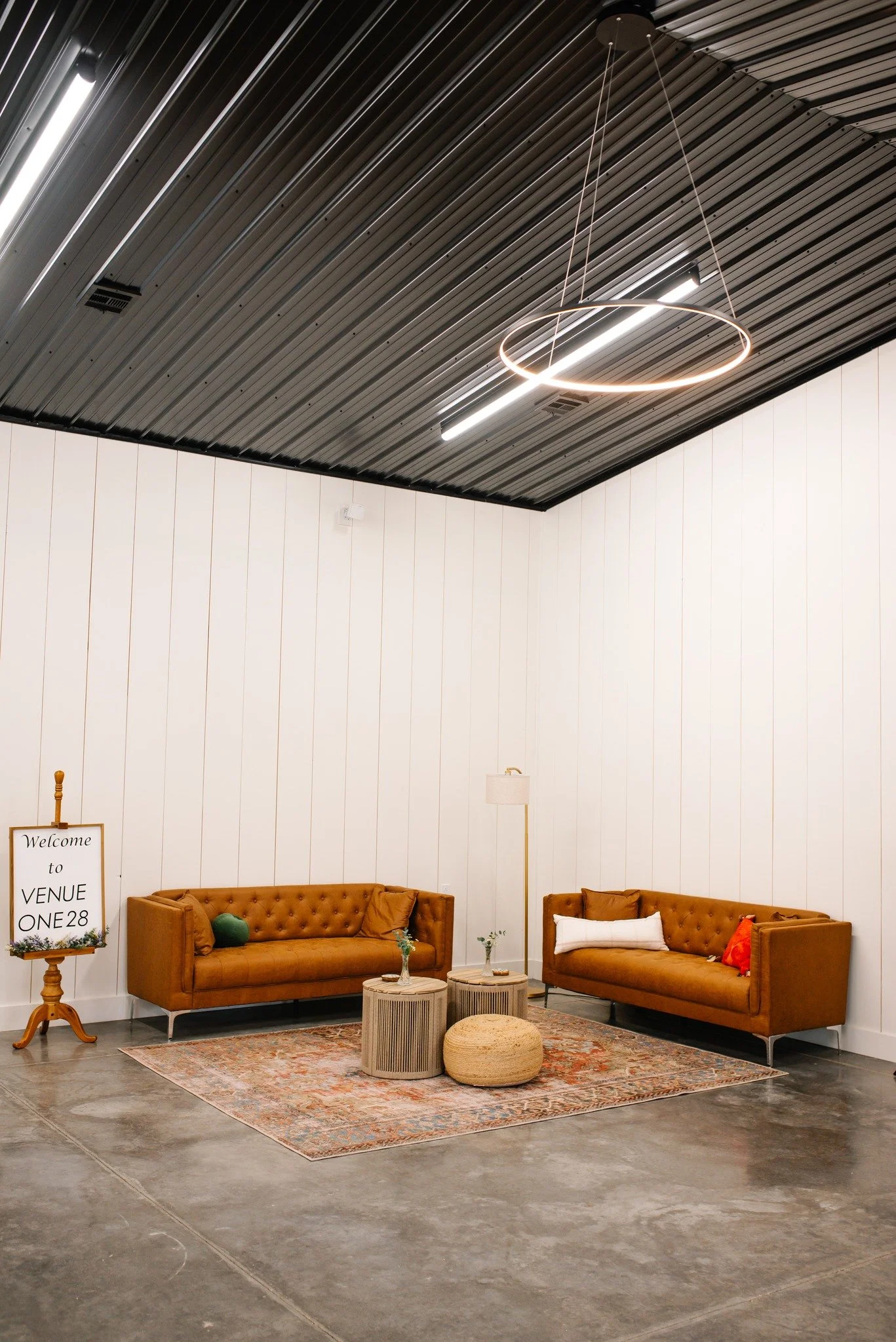 shiplap walls, leather couches and black metal ceiling; modern shabby chic