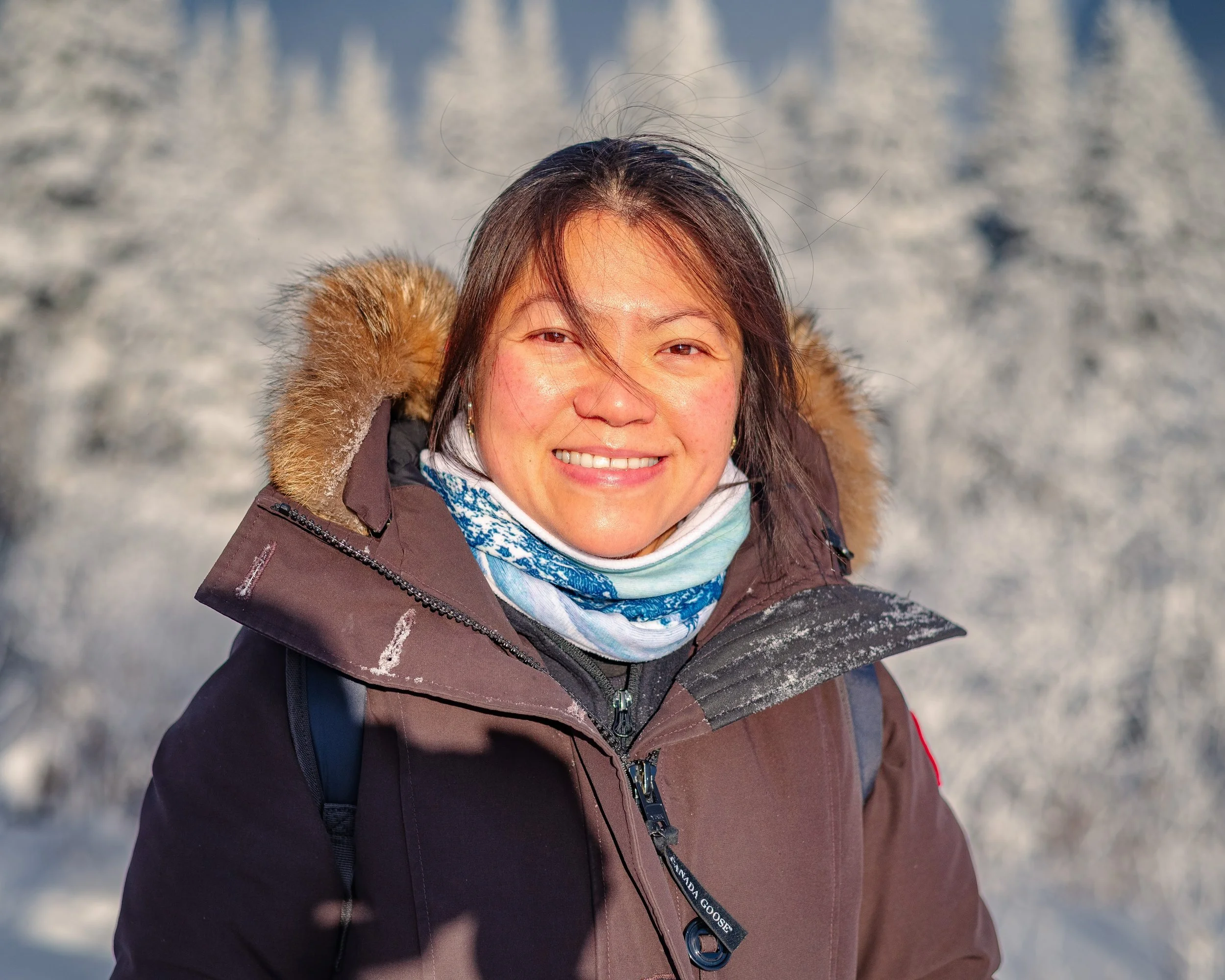 Smiling woman in winter coat outdoors in snowy landscape