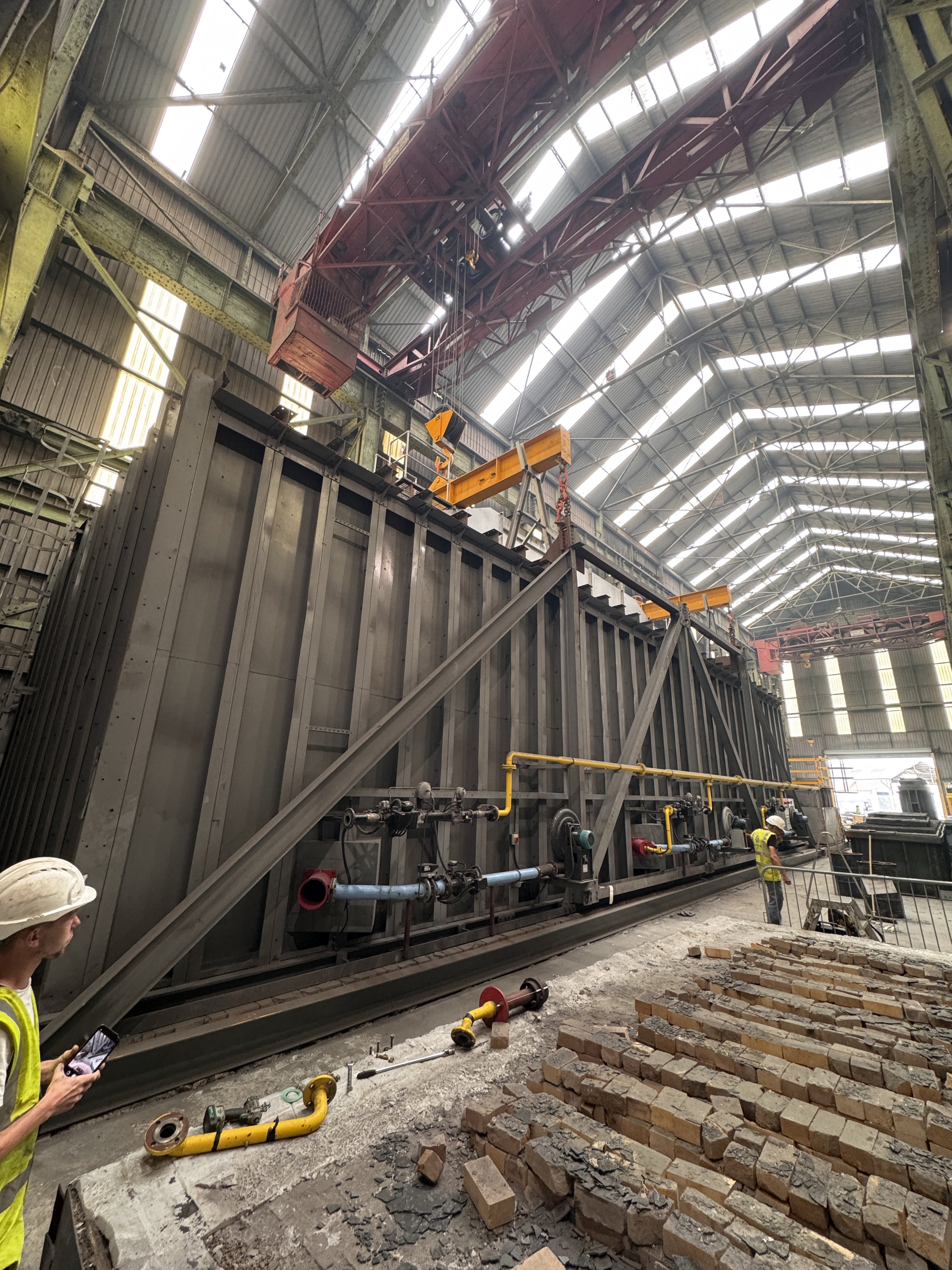 Gas-fired industrial furnace heating steel components as part of a heavy manufacturing process.