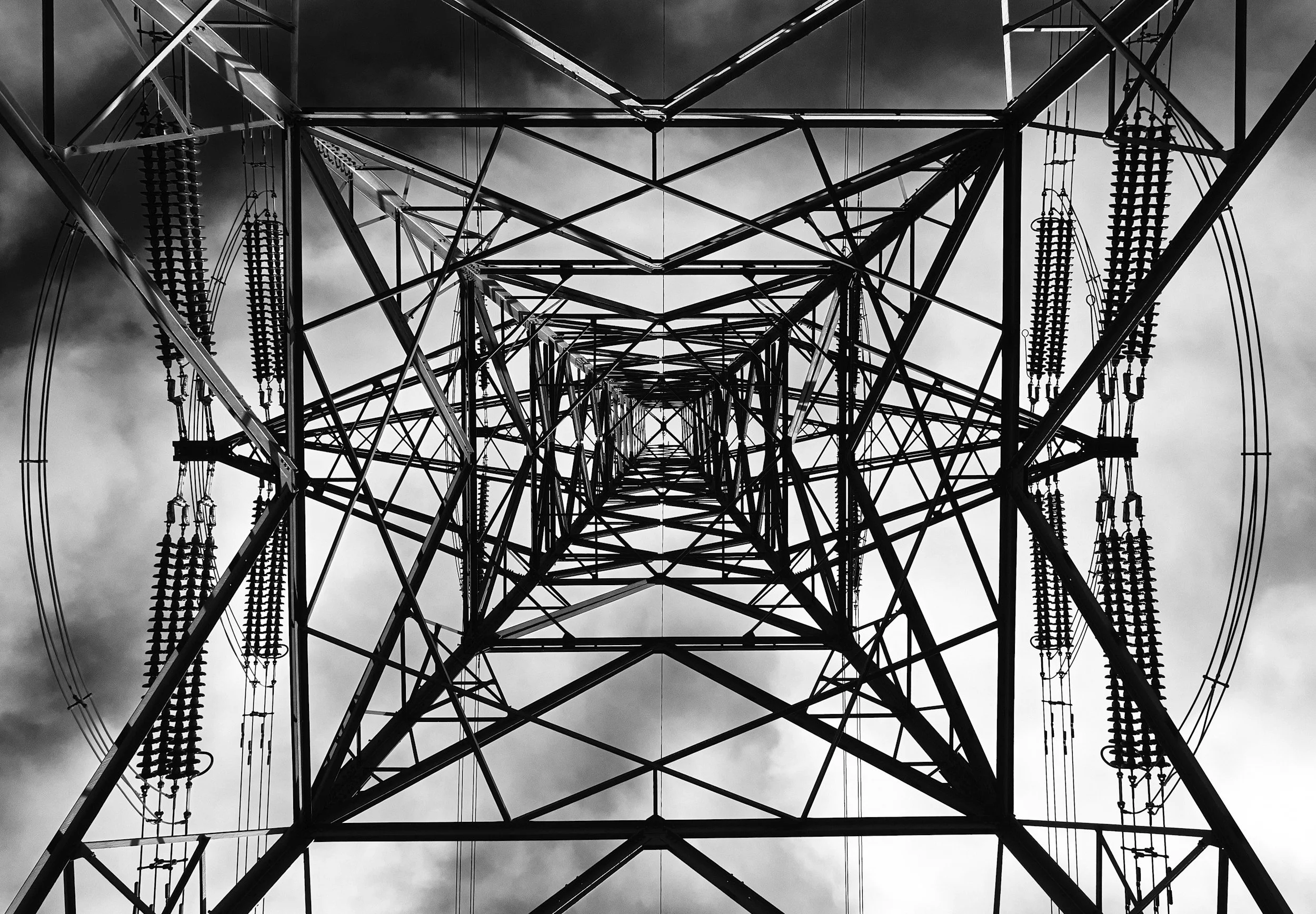 Symmetrical view looking up through a steel framework structure, representing connection, structure, and communication pathways.