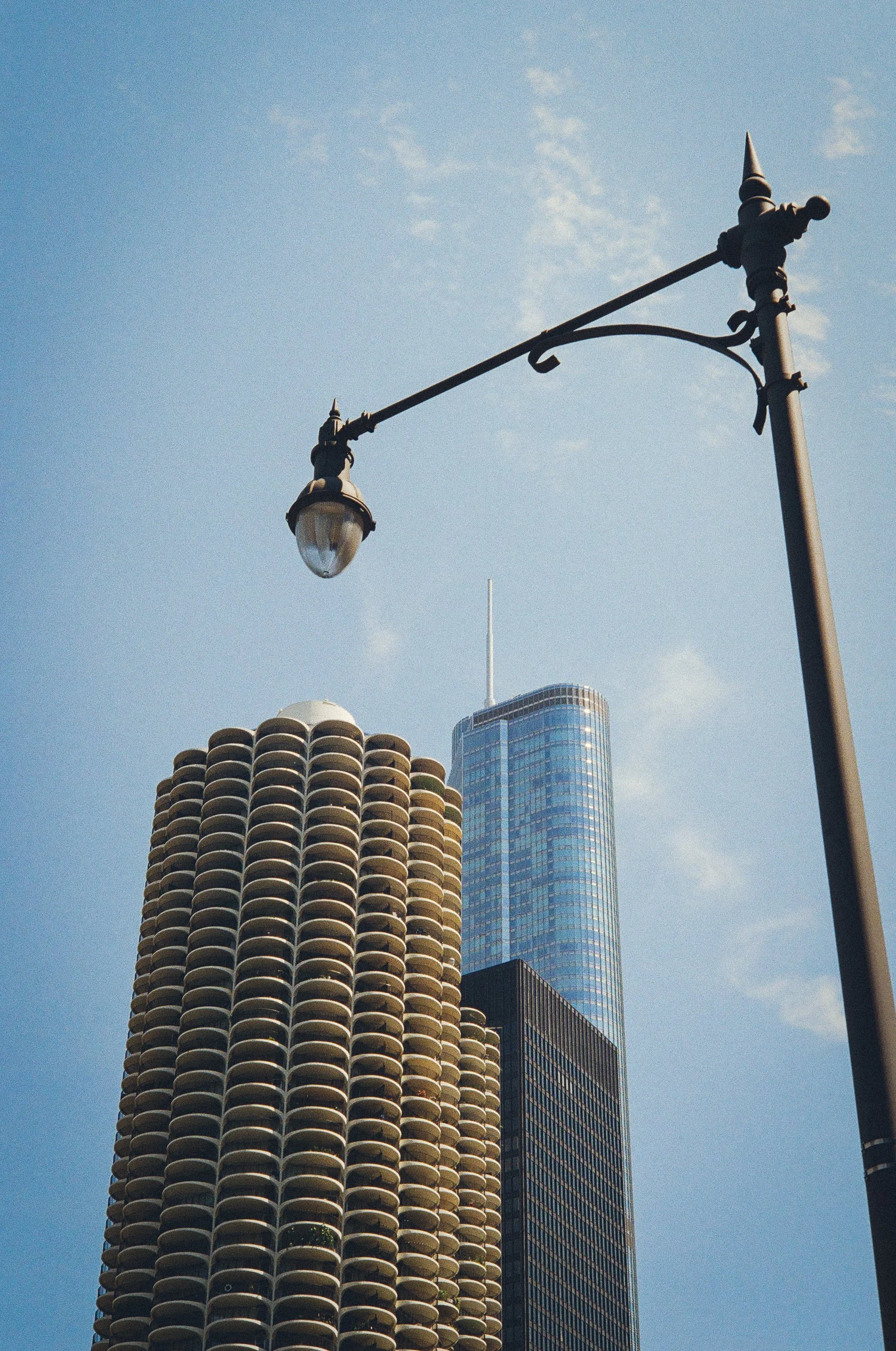 View of city buildings with a street lamp in the foreground against the sky.