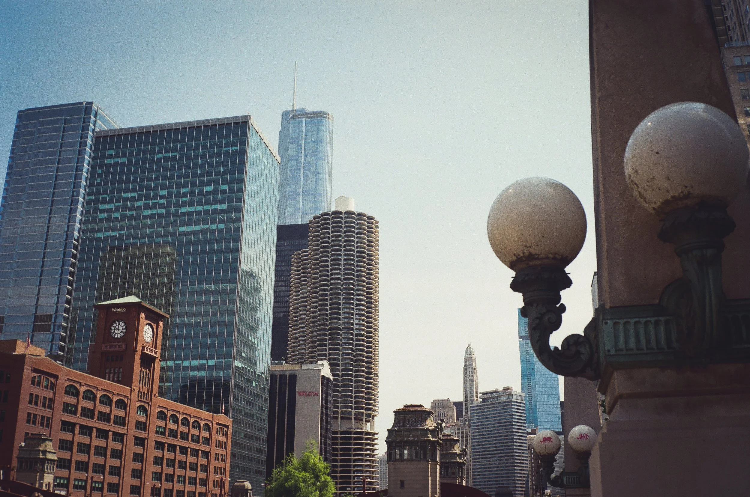 City skyline with modern skyscrapers, historic buildings, and street lamps with dirty, spherical glass globes in an urban setting.