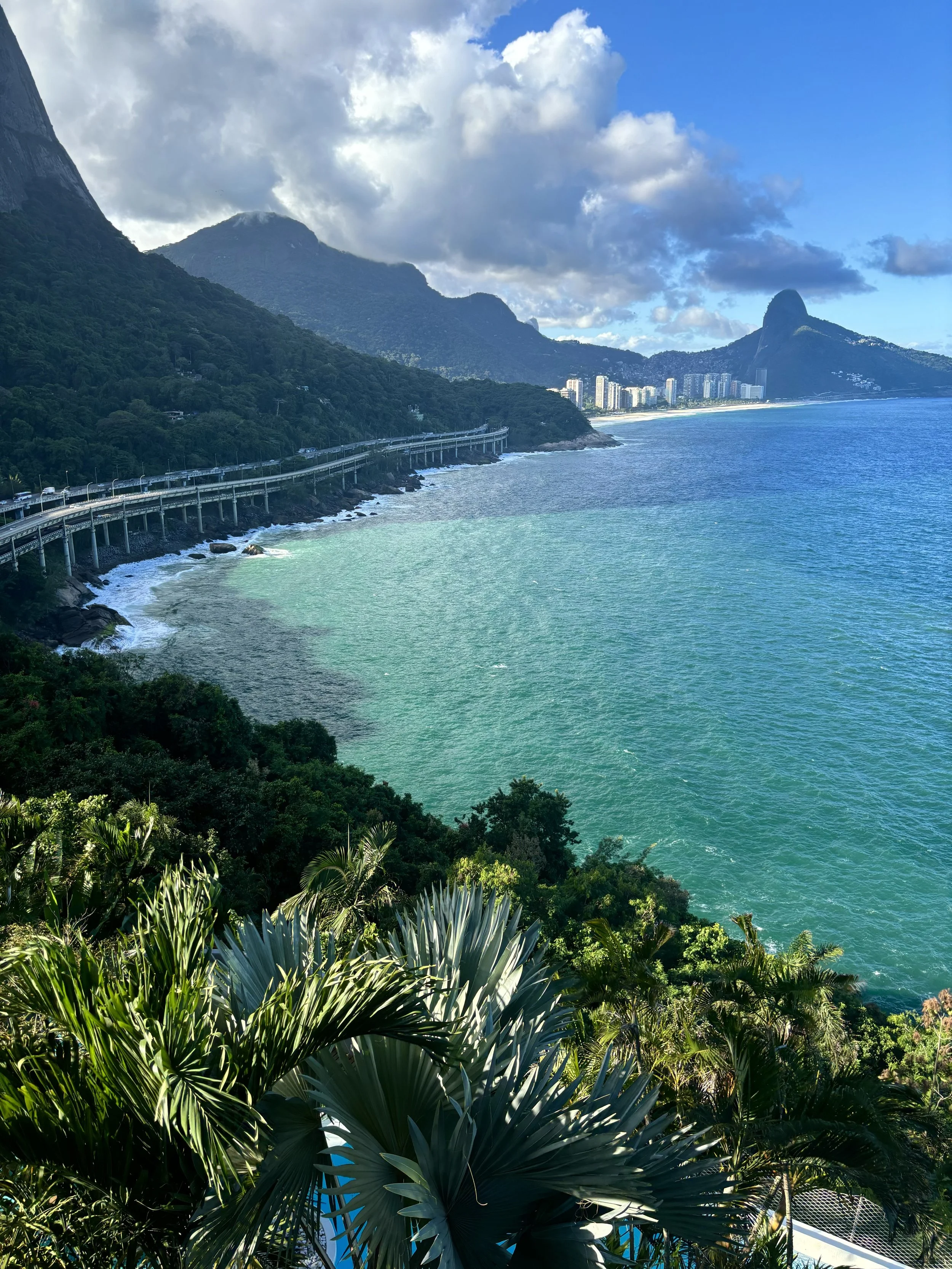 La Suite by Dussols, Rio de Janeiro — Perched where the Atlantic forest surrenders to the sky, the eye is drawn not to the city but past it, to the liquid horizon where mountain, ocean, and light negotiate a truce. Rio exists here only as a suggestio