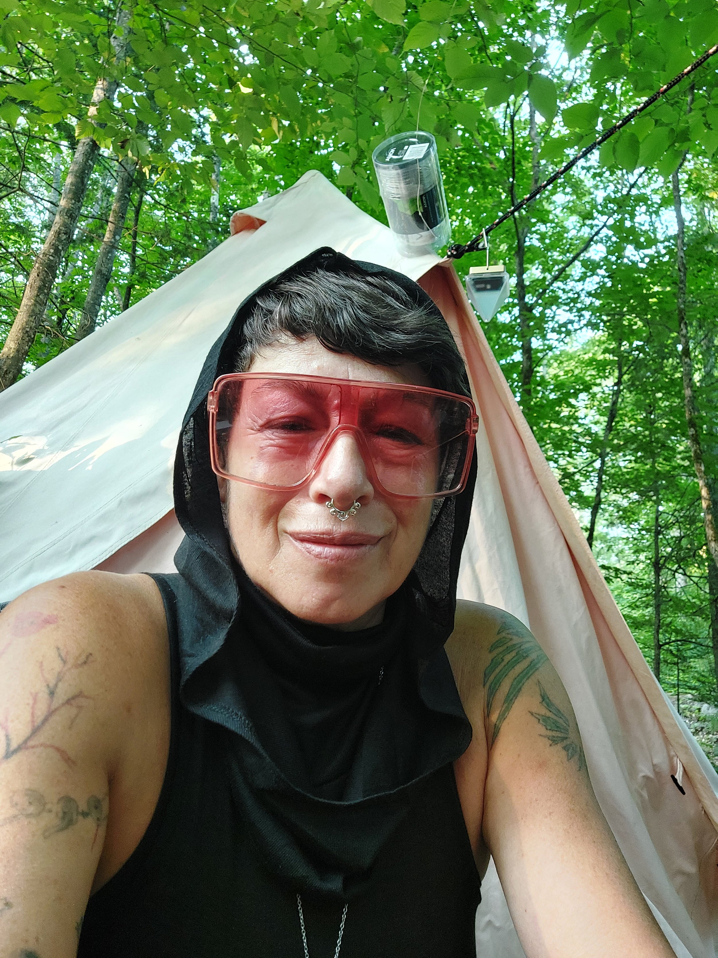 Earth-based practitioner, Slava is in a hammock with large pink glasses