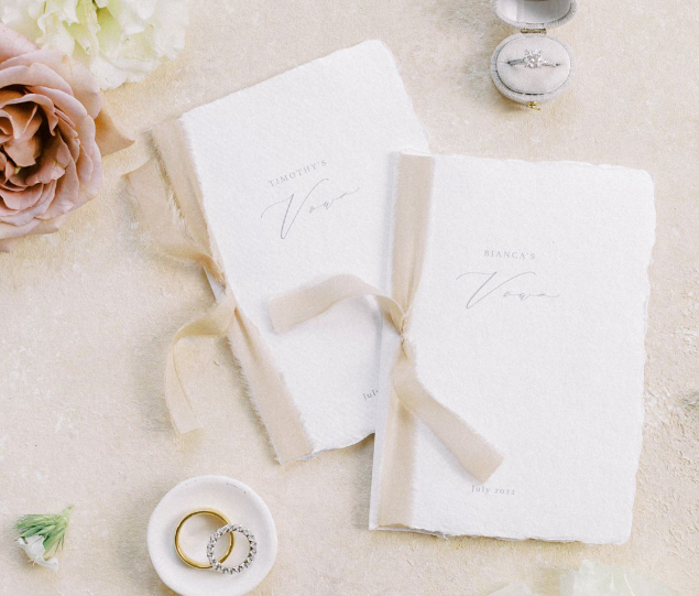 Laurie’s customers, Mariana and Carmen holding hands on a green lawn on their wedding day.