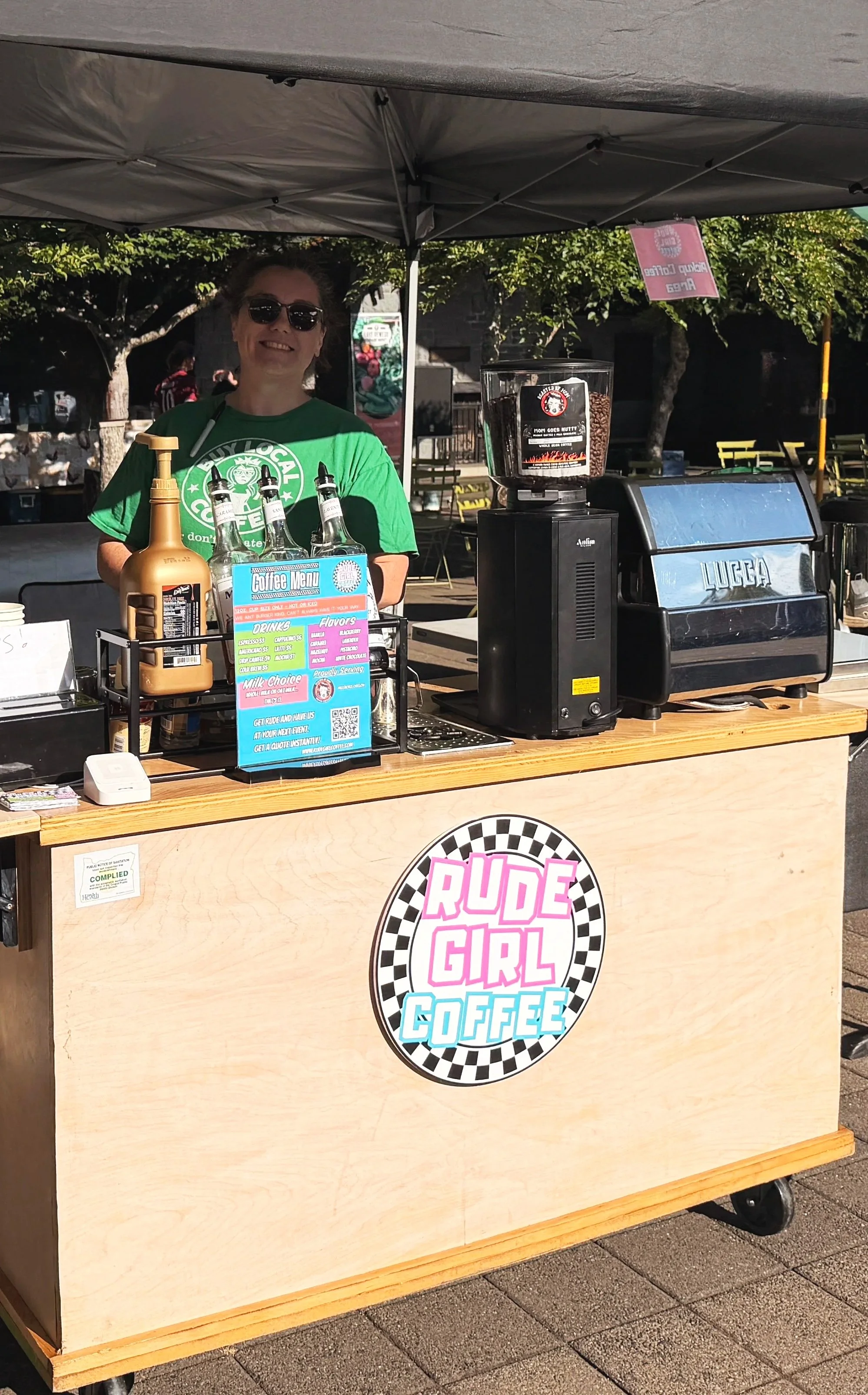 owner standing behind the rude gil coffee cart smiling.