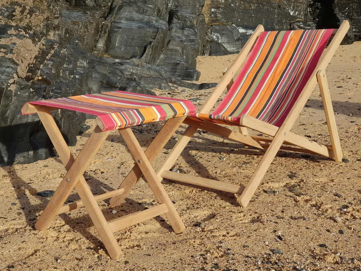 Handmade wooden deckchair and footstool on a beach in North Cornwall