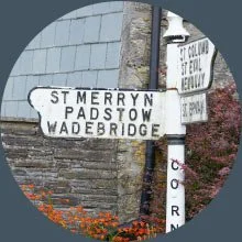 Street sign with names: St Merrynn, Padstow, Wadebridge, and a partially visible sign for Cornwall