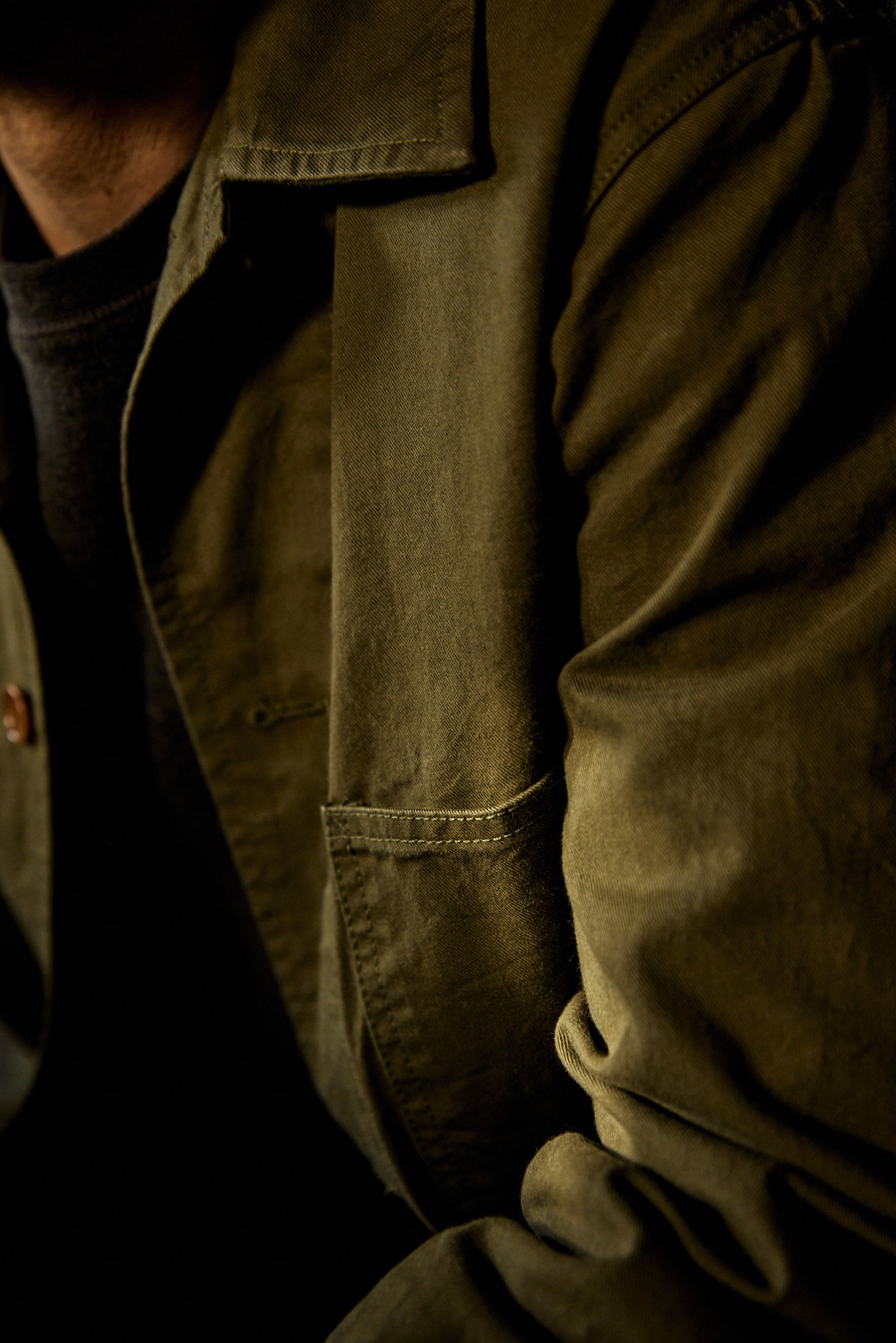 Close-up of a person wearing an olive green jacket 
