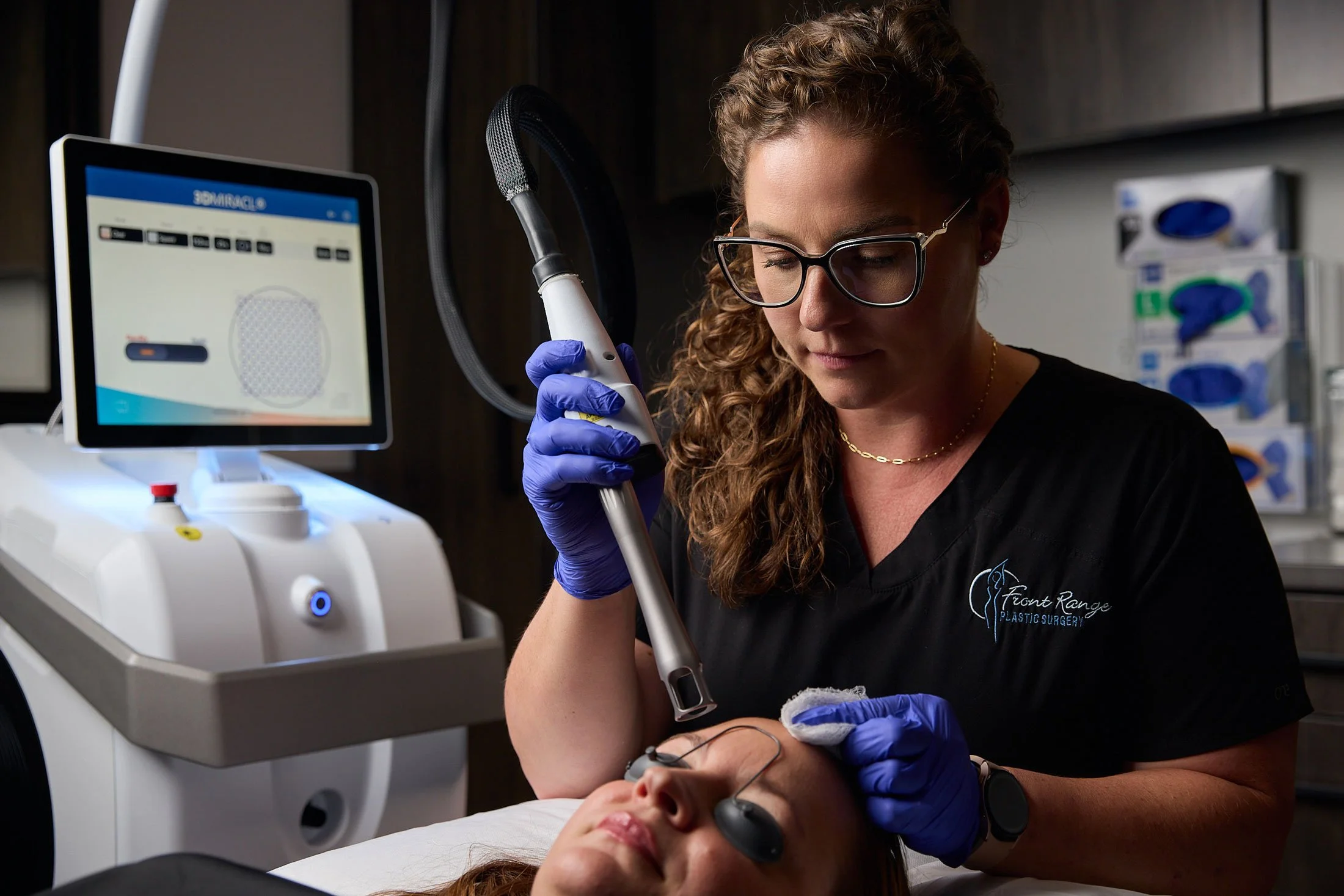 Medical technician using cold laser on patients skin