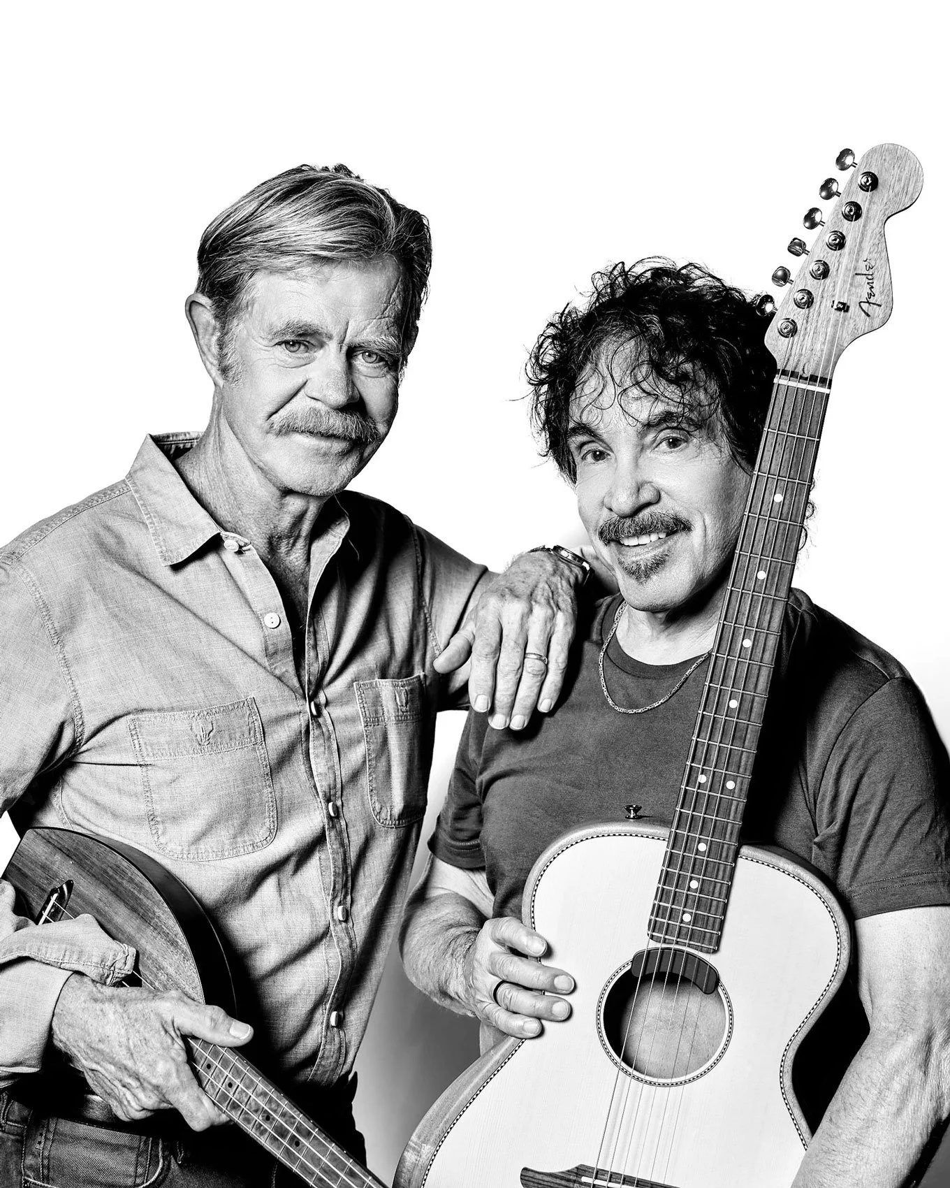William H. Macy and John Oates posing with their instruments