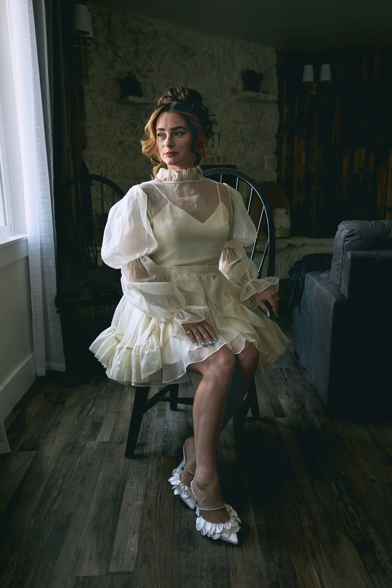 Bride seated in a dark room wearing an eclectic dress