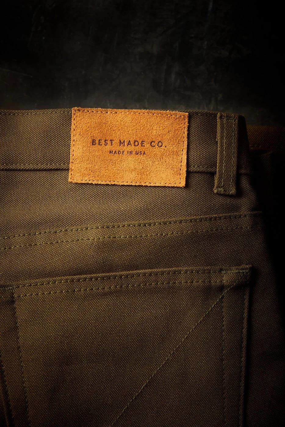 Close-up of green back pants pocket with a leather patch label reading 'Best Made Co. Made in USA'.
