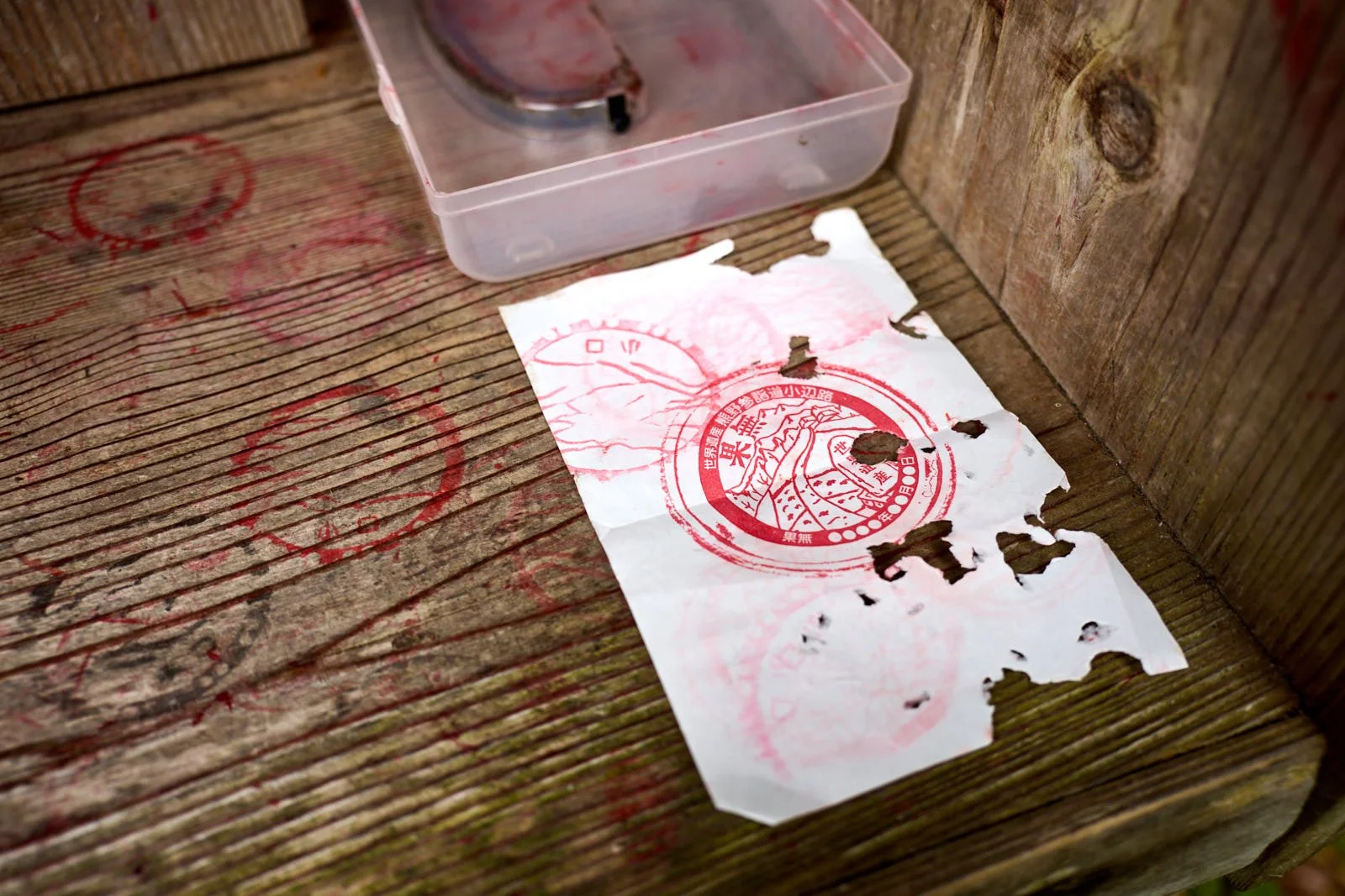 Paper with red ink stamps on a wooden surface.