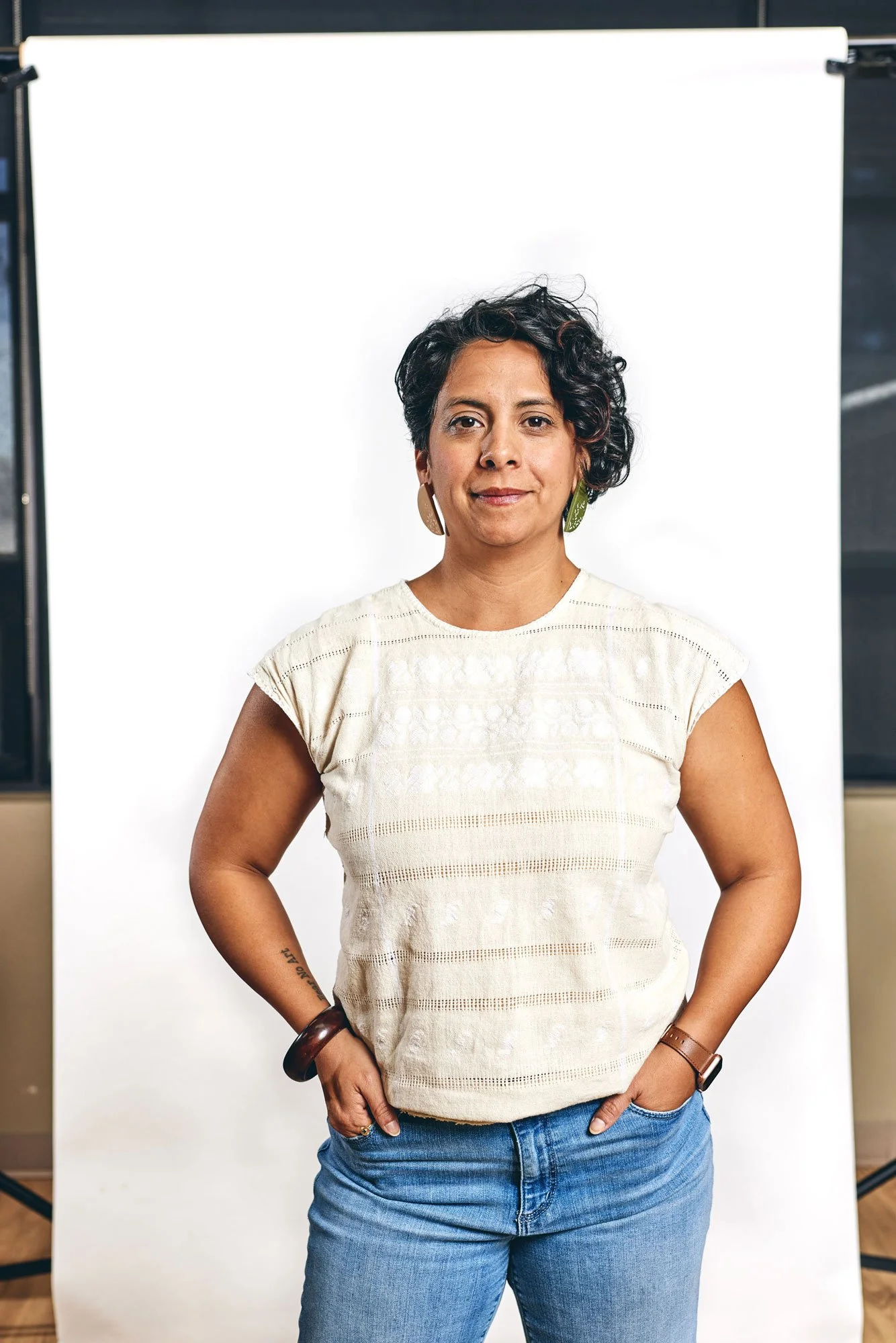 Woman in blue jeans standing in front of a white backdrop