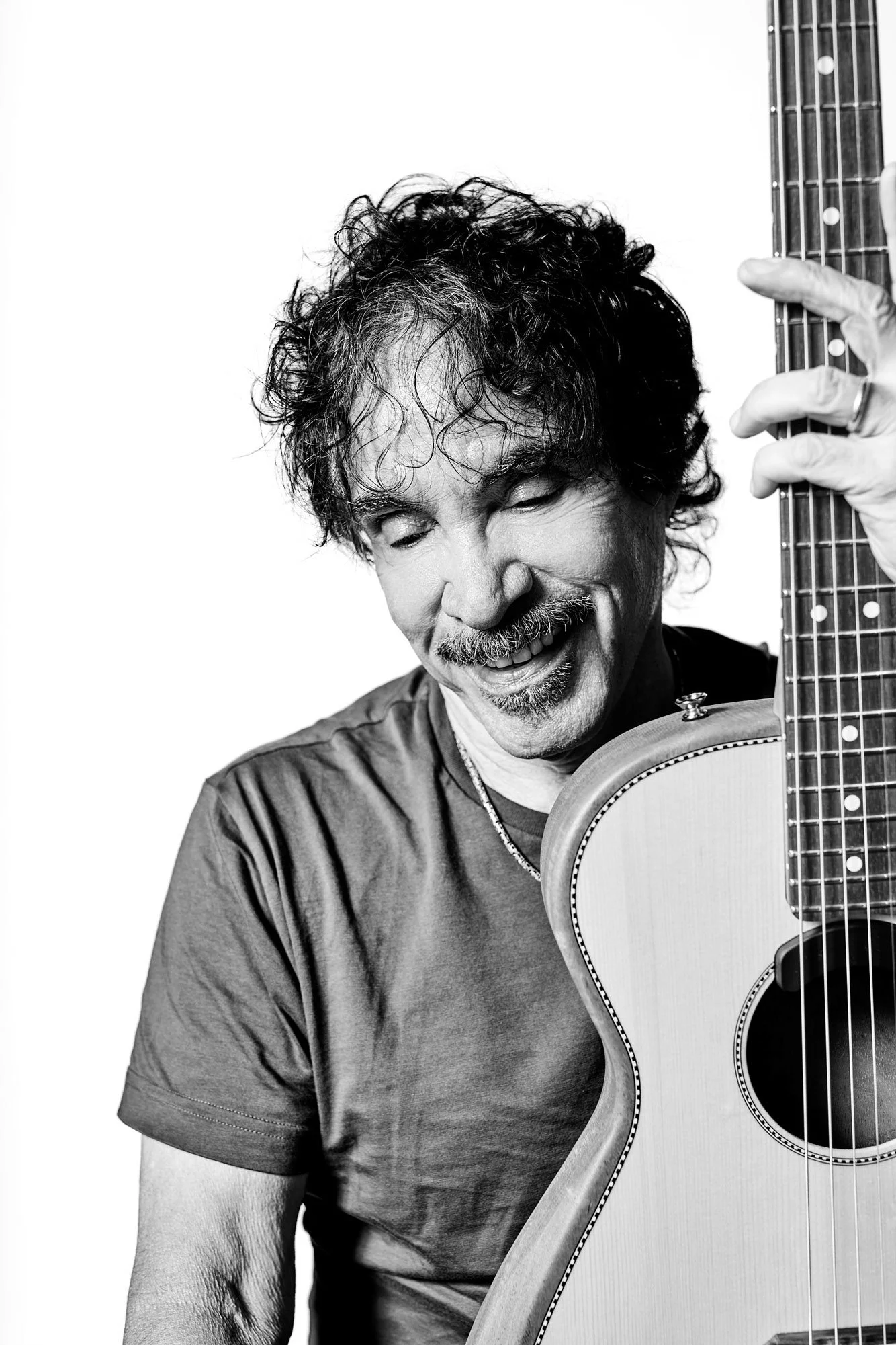 Black and white portrait of musician John Oates holding his guitar