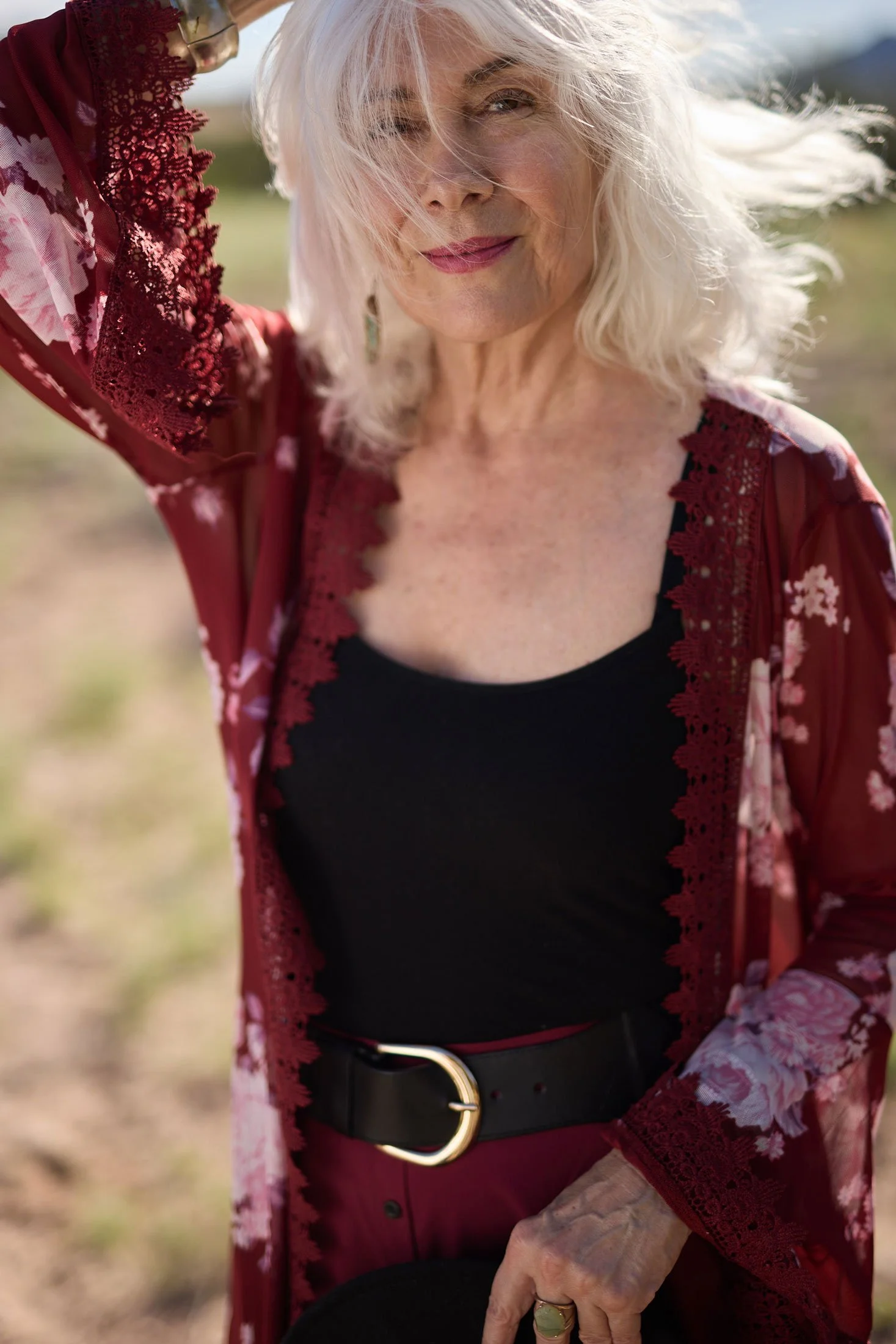 Model in a red outfit holding down her wind blown hair