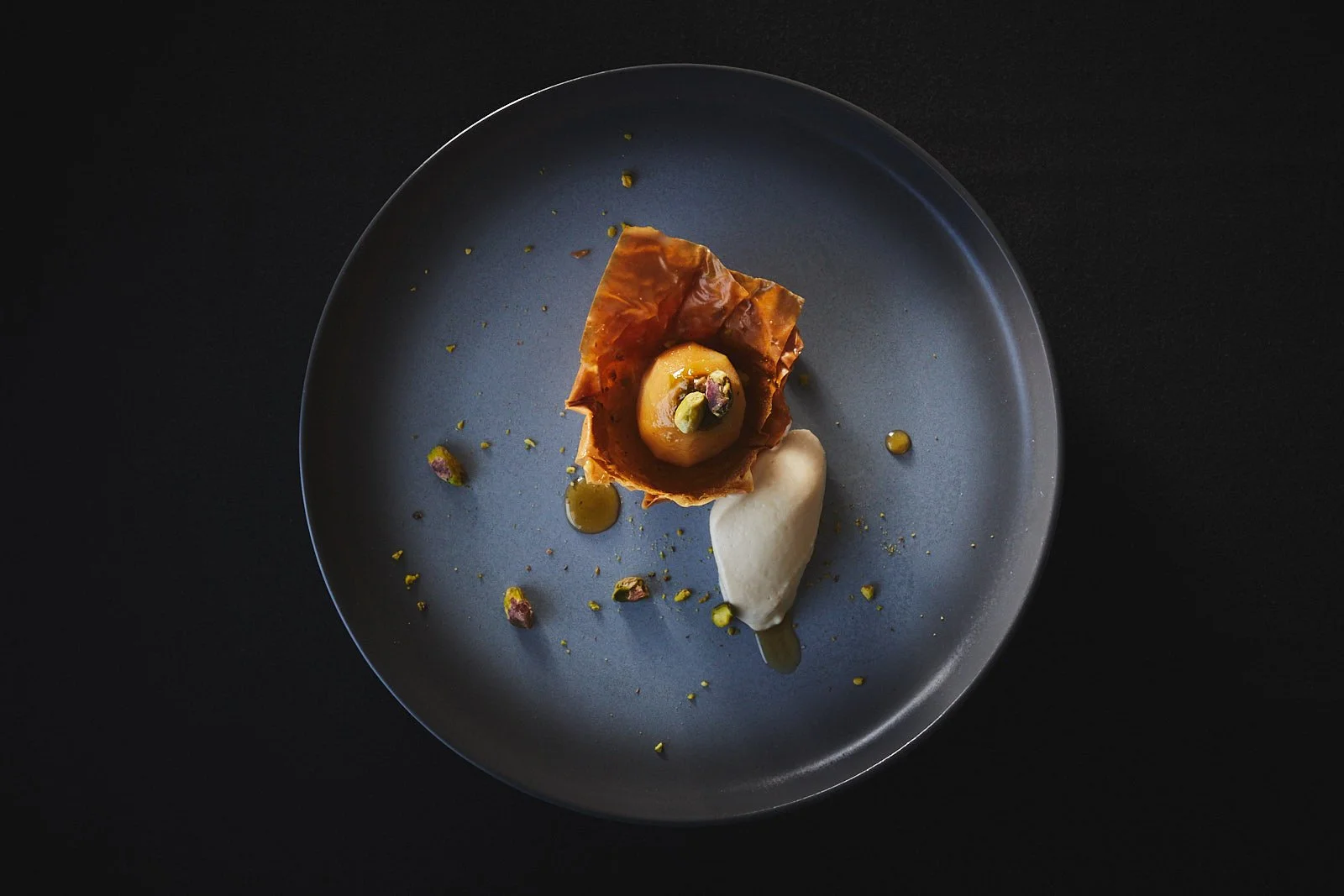 Pear dessert on a dark plate and black tablecloth at Chimney Park restaurant in Windsor Colorado
