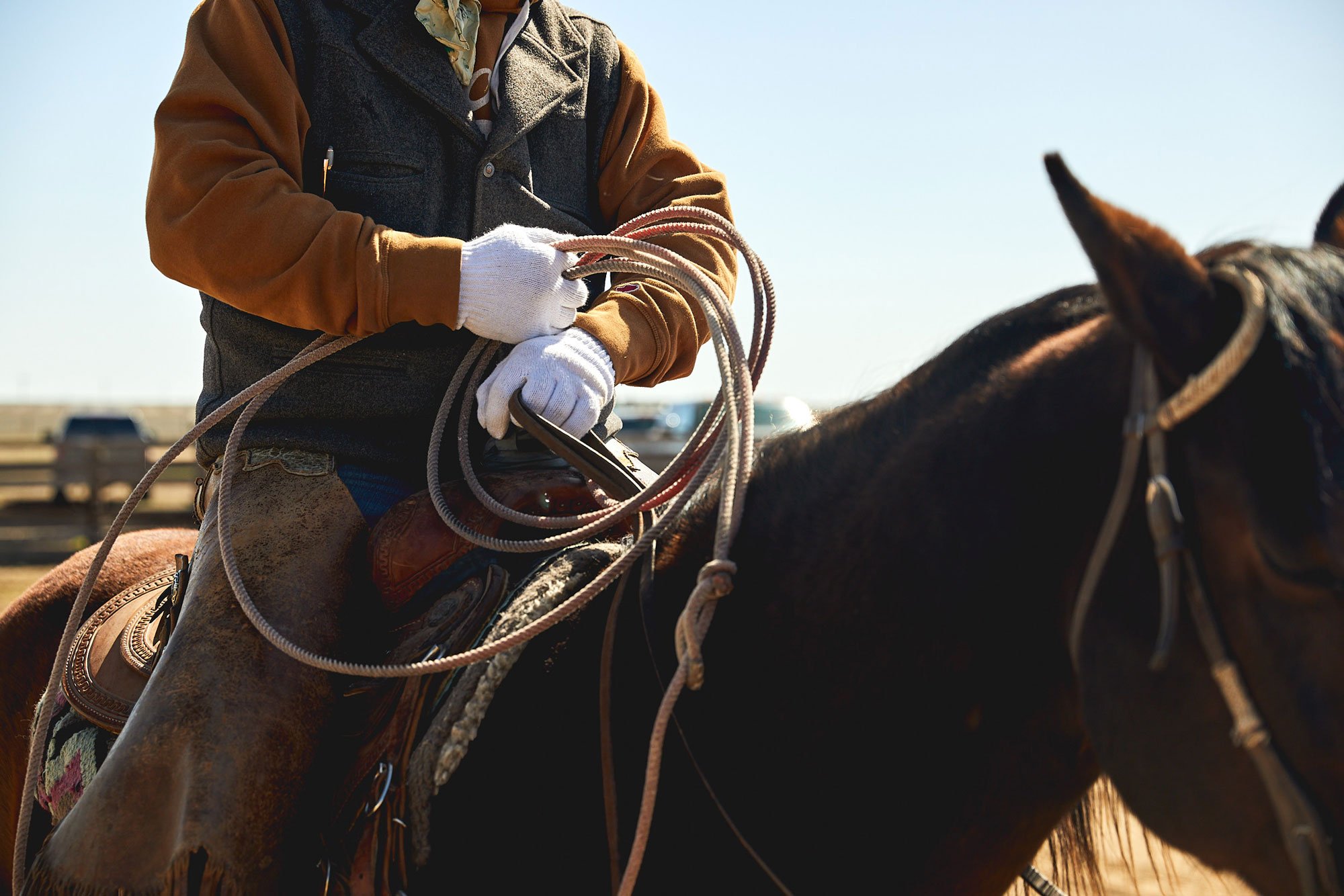 Cowboy on horse wearing white gloves