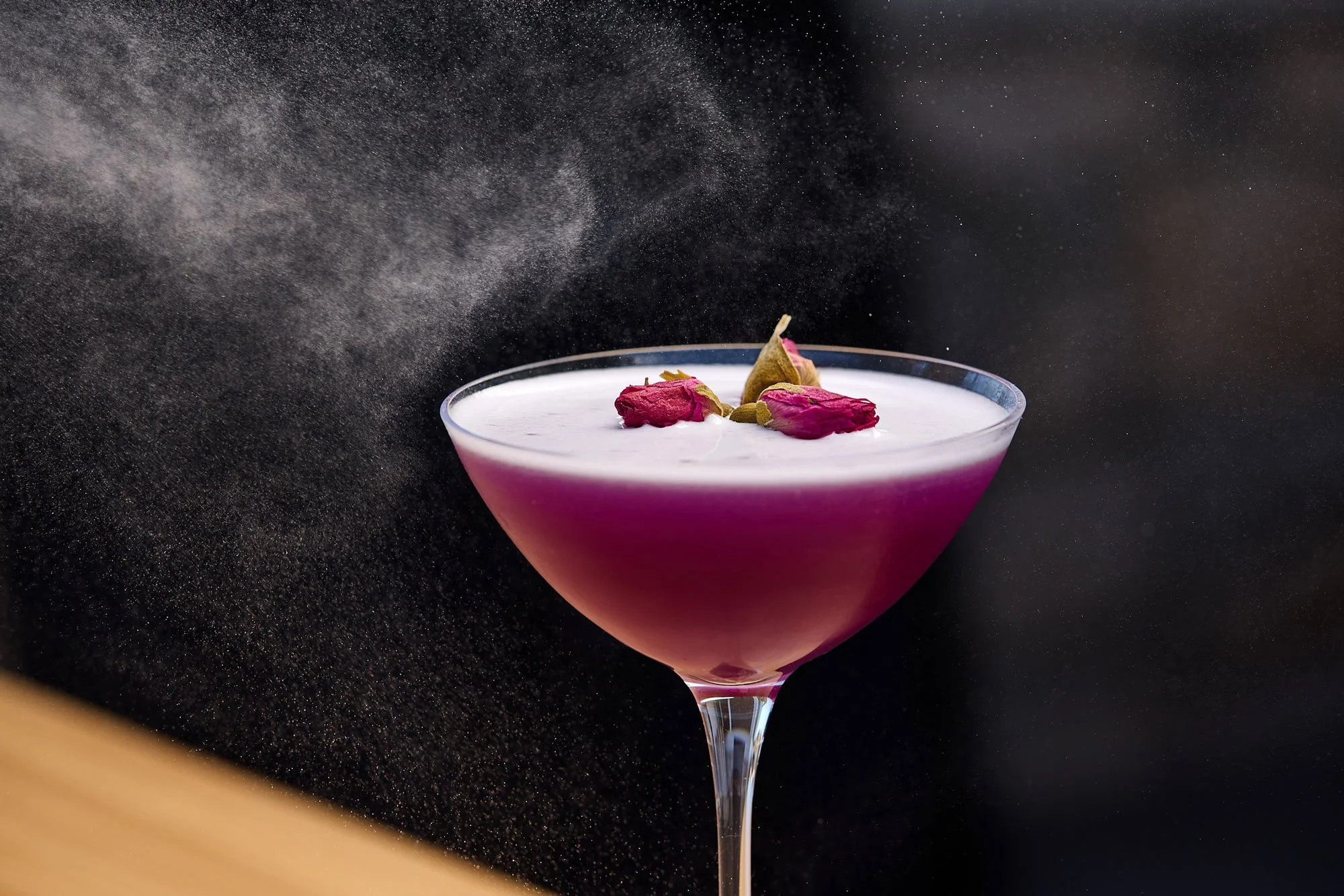 Rose cocktail in coupe style glass being misted