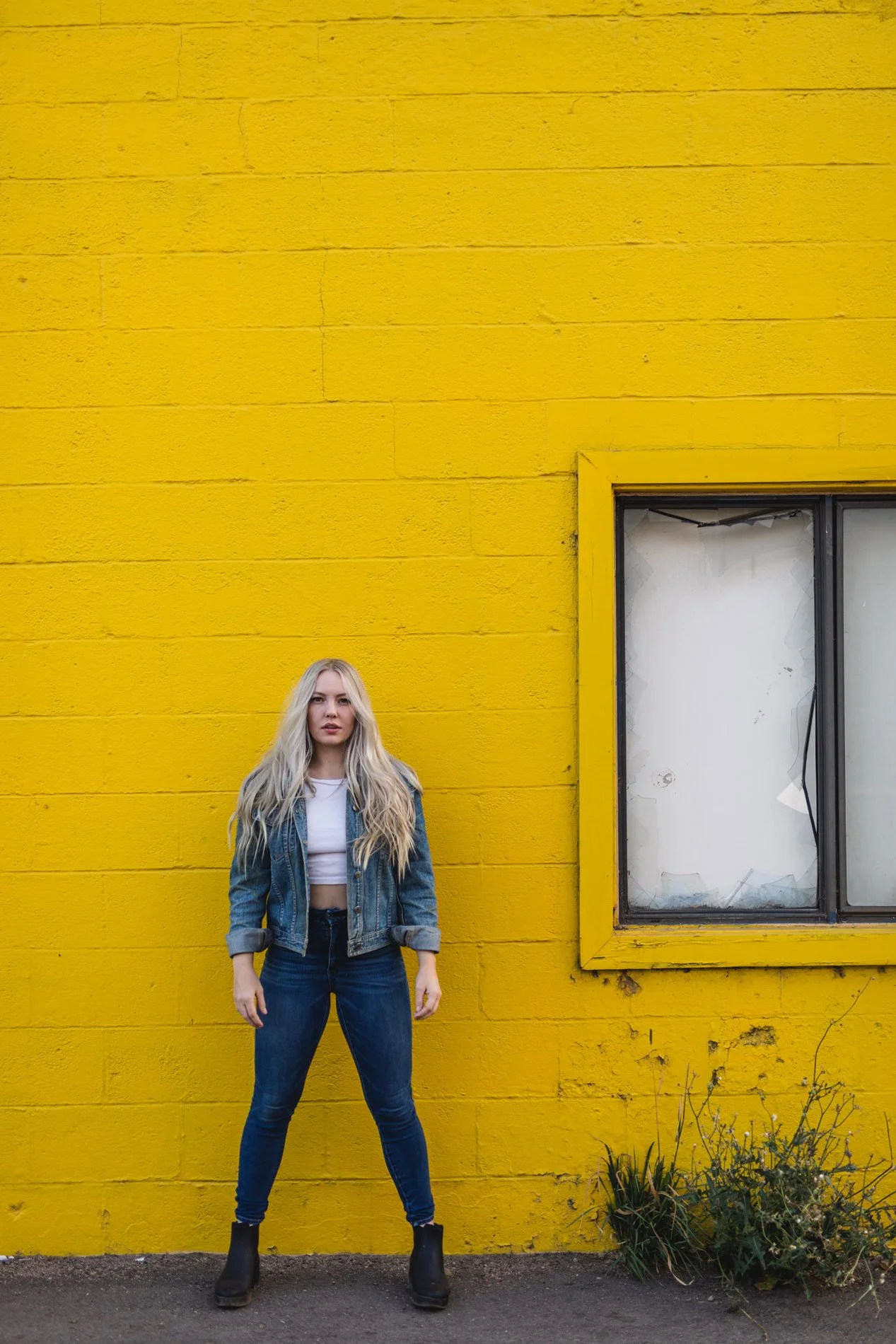 Model wearing denim in front of a yellow wall