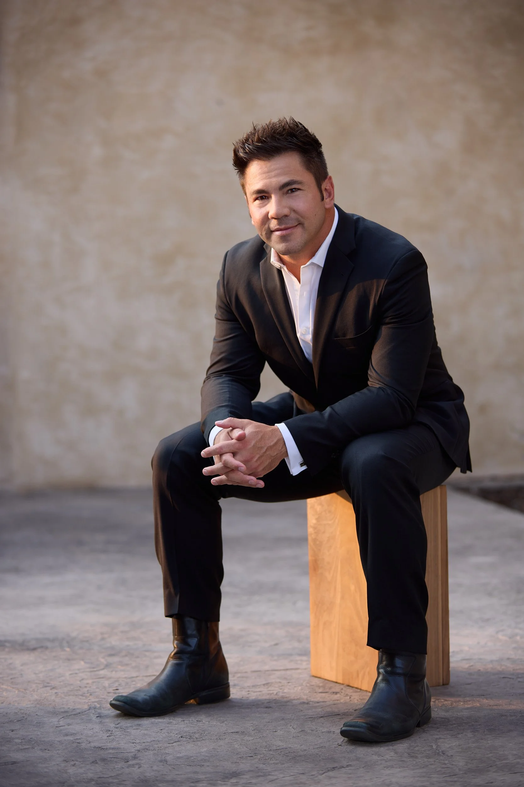 Man in suit seated on an apple box