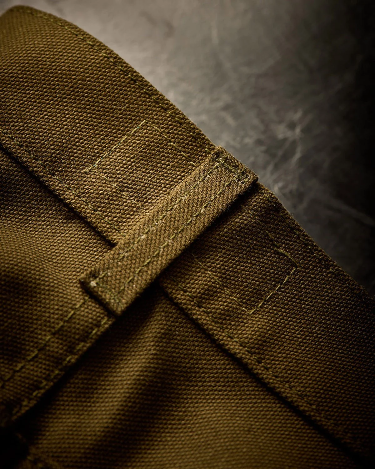 Close-up of olive green pant belt loop
