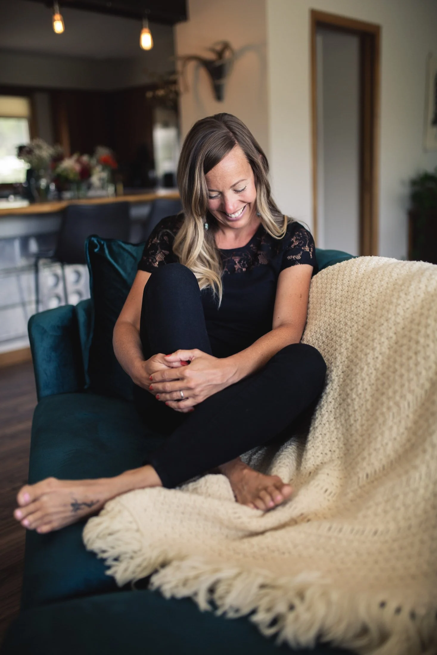 Woman casually seated on a turquoise couch