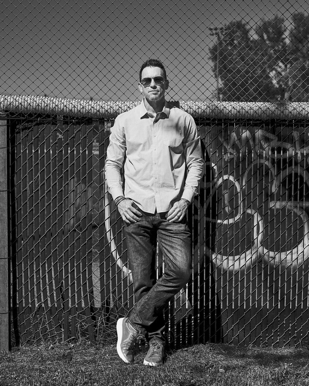 Black and white portrait of Philadelphia Phillies pitcher Brad Lidge in front of an baseball field outfield fence in Boulder, Colorado