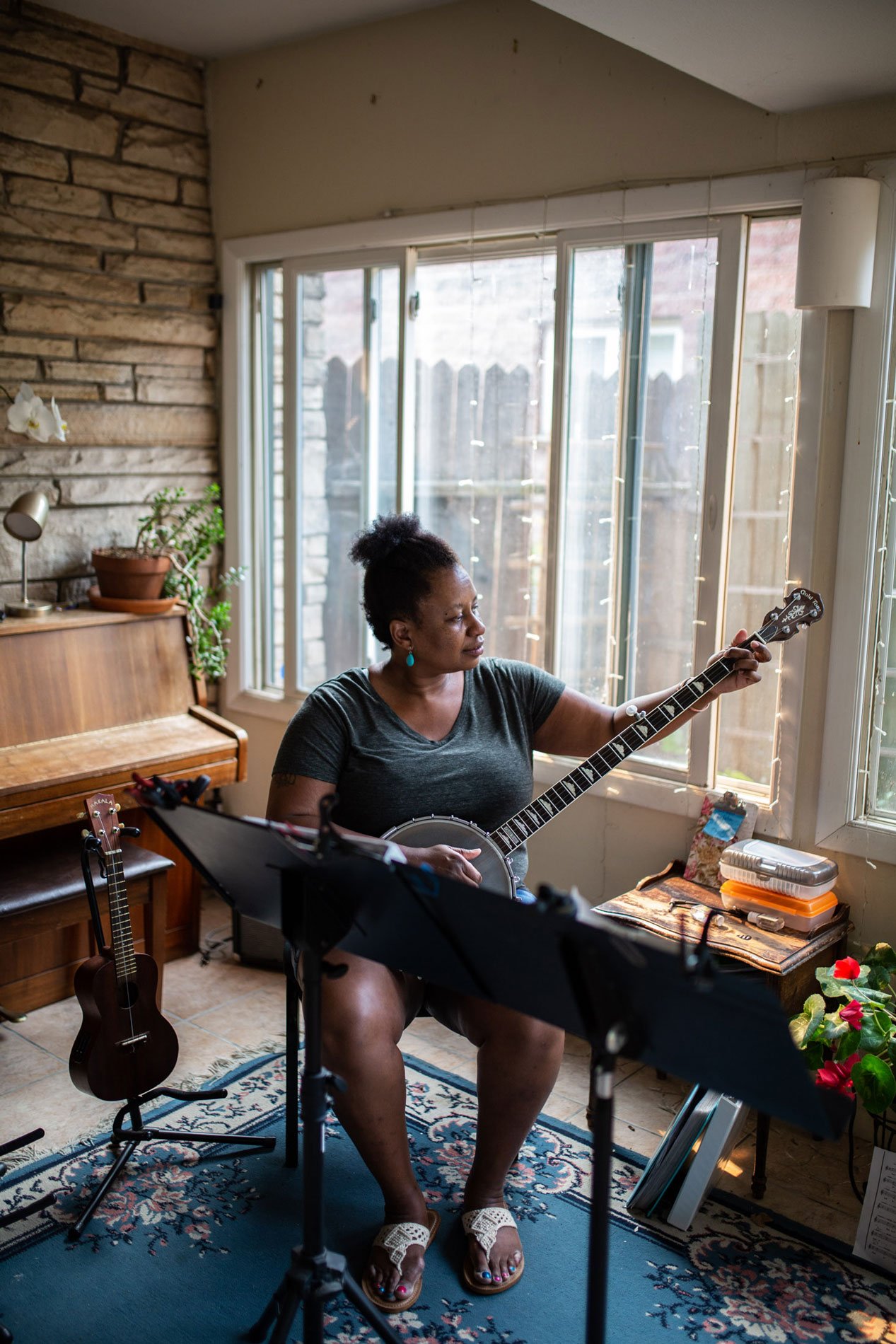 Musician playing a banjo in her home studio