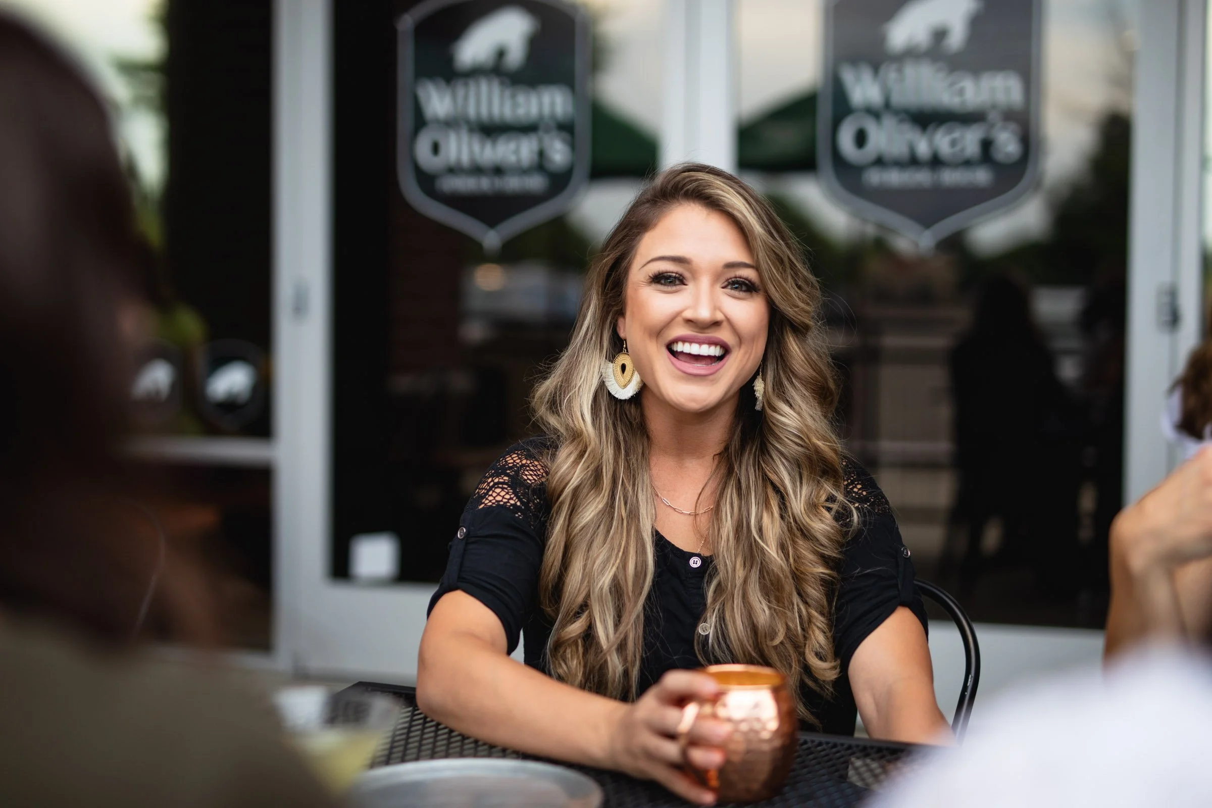 Woman enjoying a Moscow Mule on the patio of William Olivers in Fort Collins