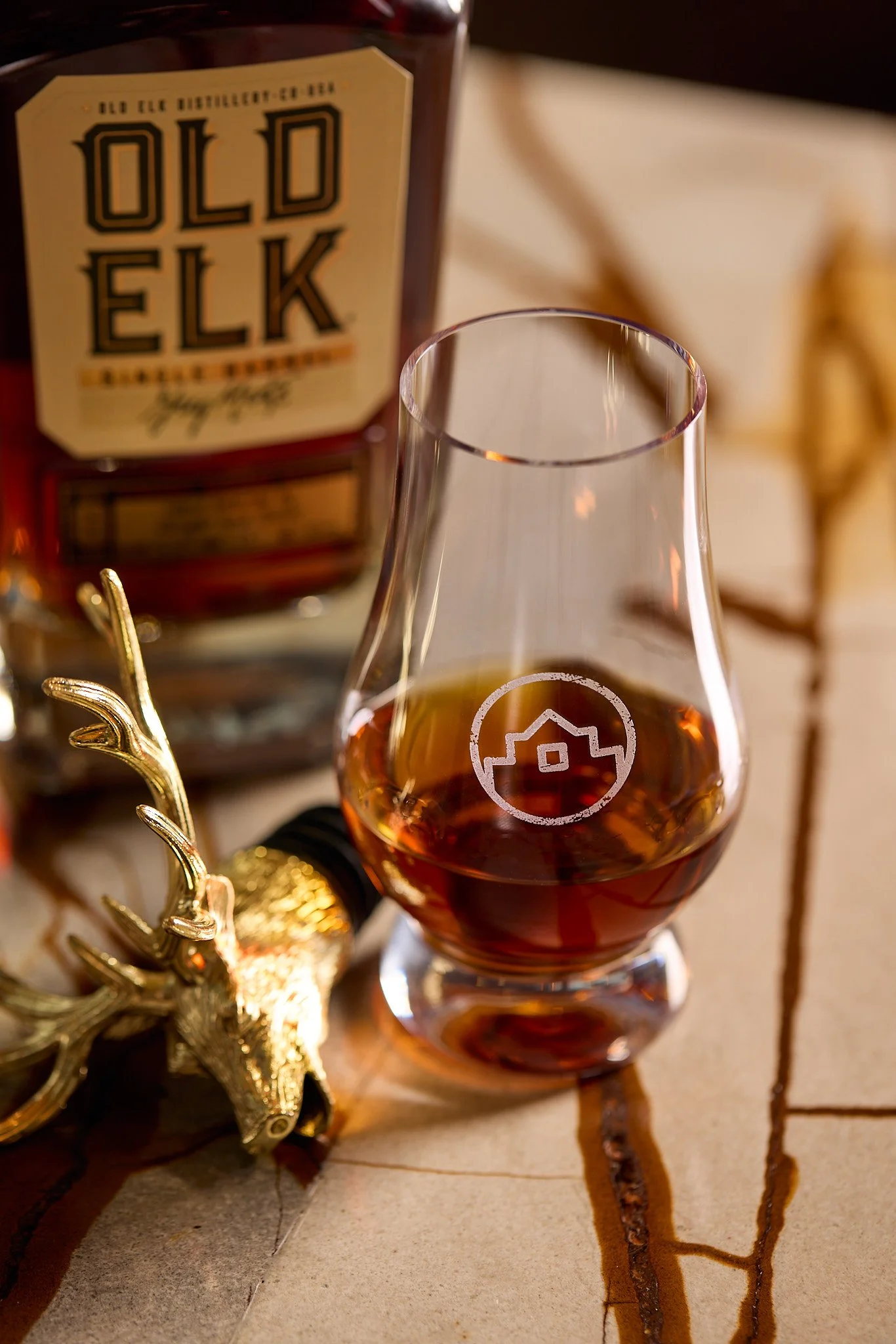Snifter of Old Elk whiskey in front of bottle