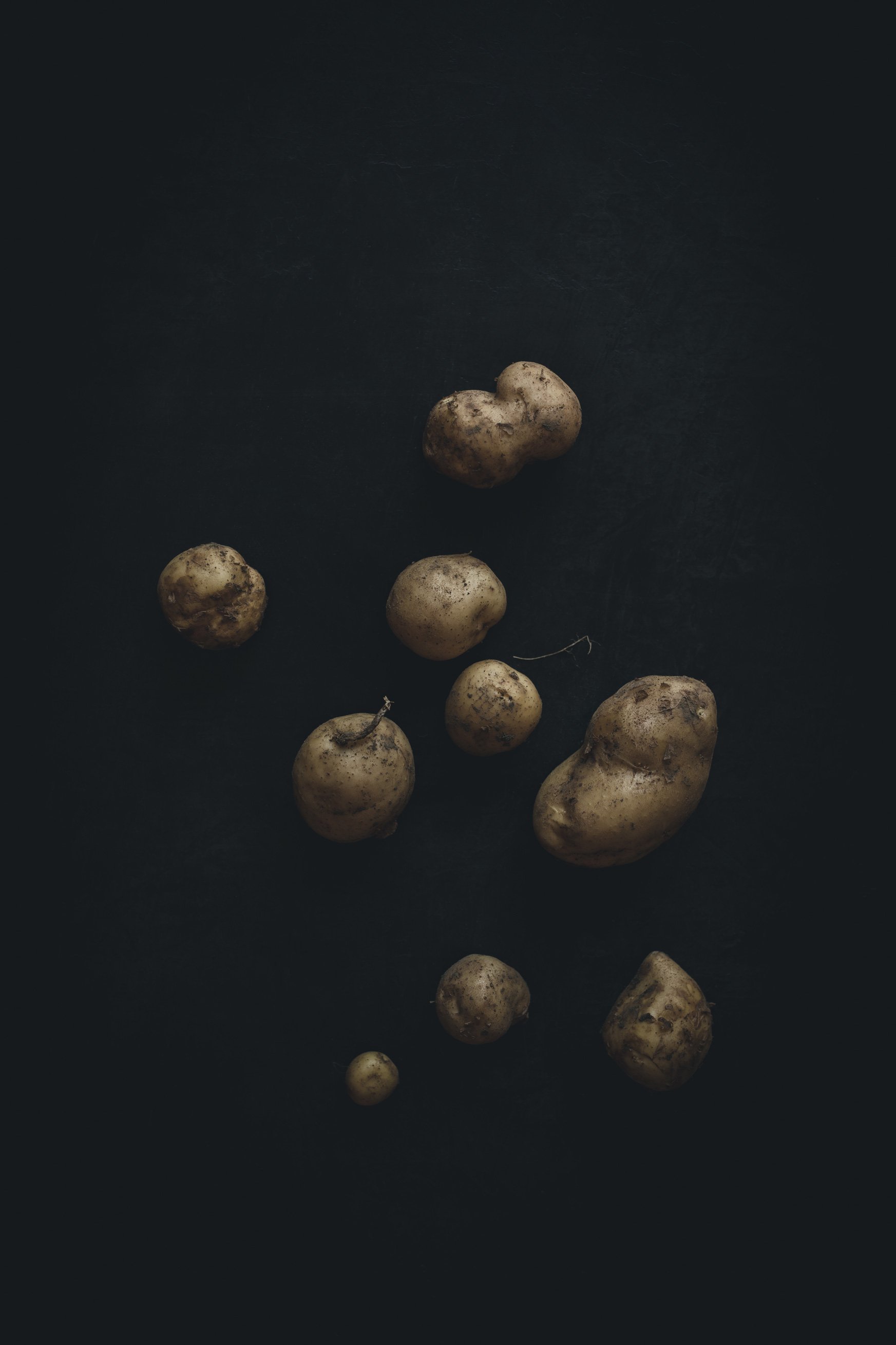 Potatoes on a dark surface.