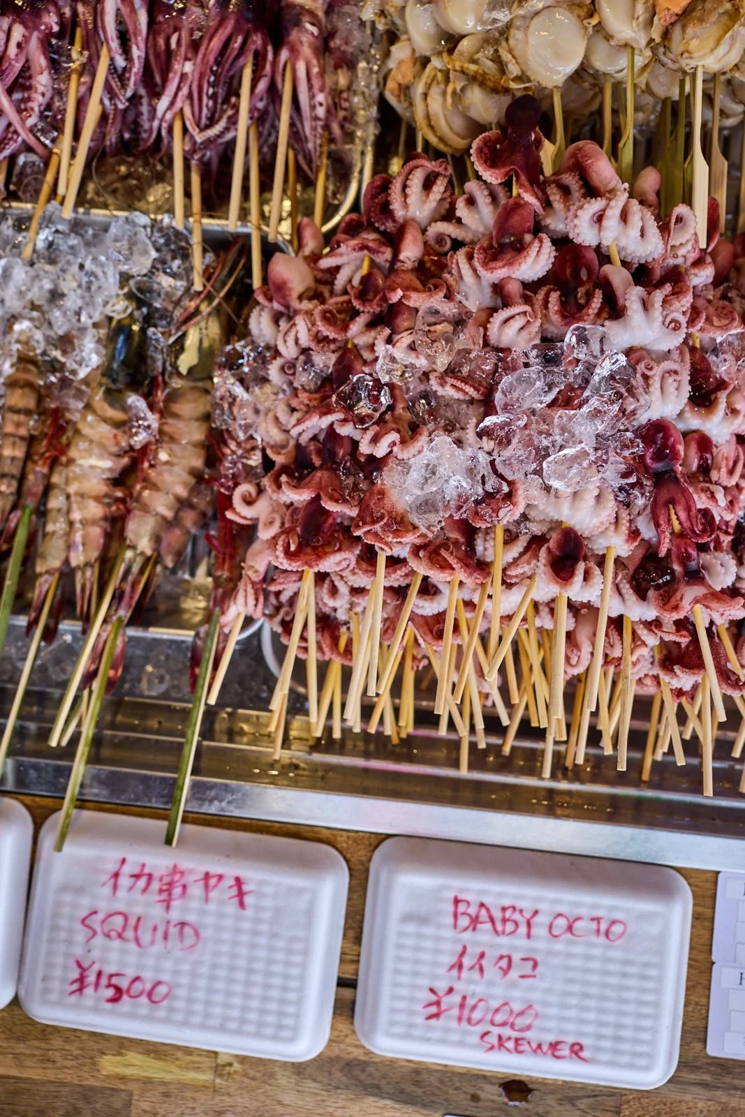 Skewers with baby octopus on ice at a market.