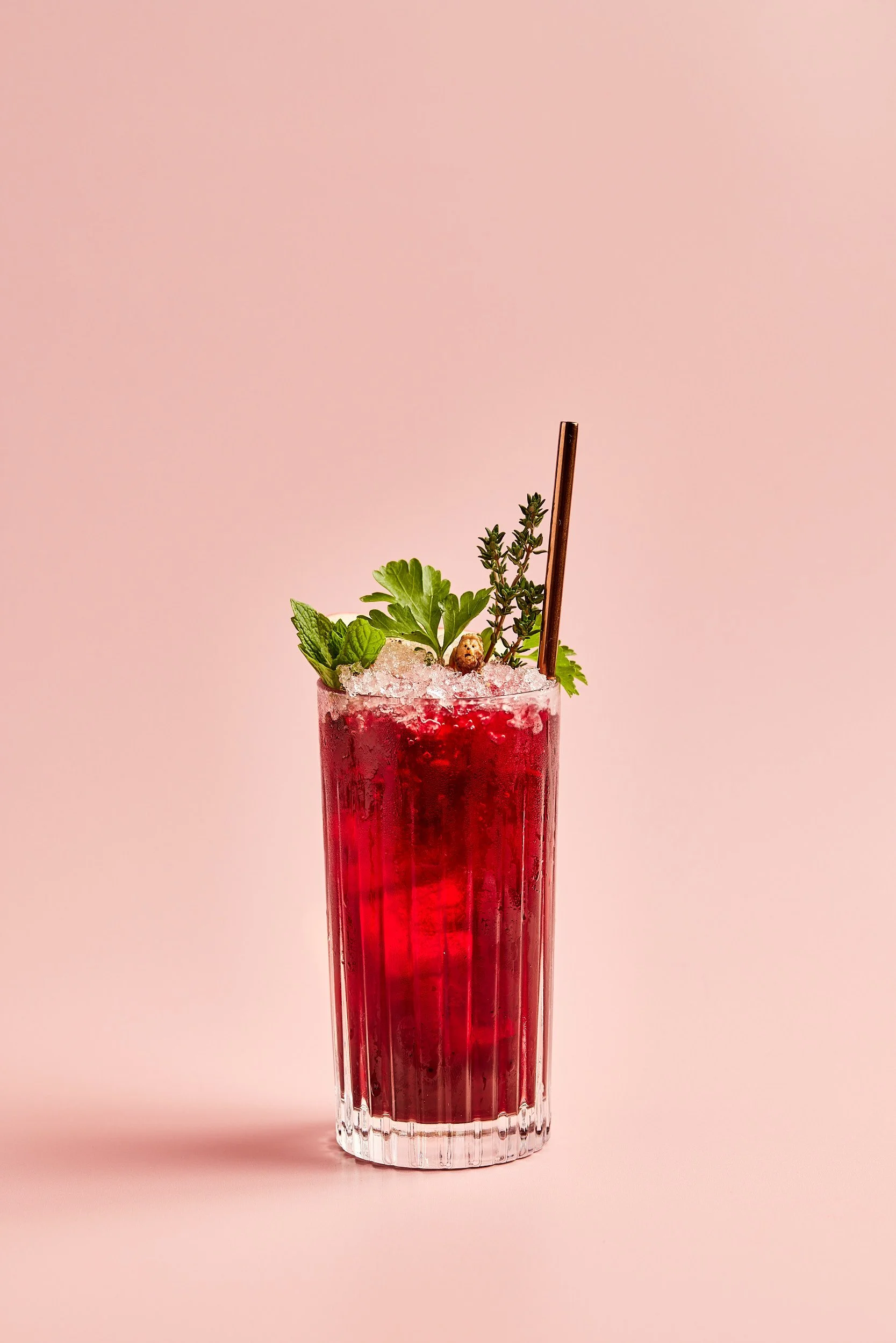 Tall red cocktail on a pink background