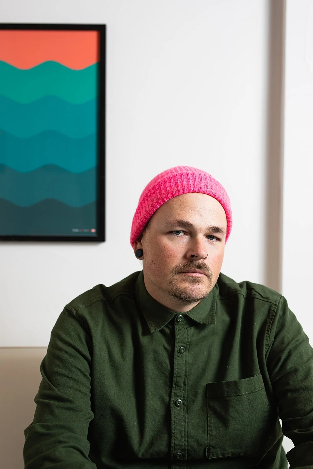 Designer wearing a green shirt and pink hat